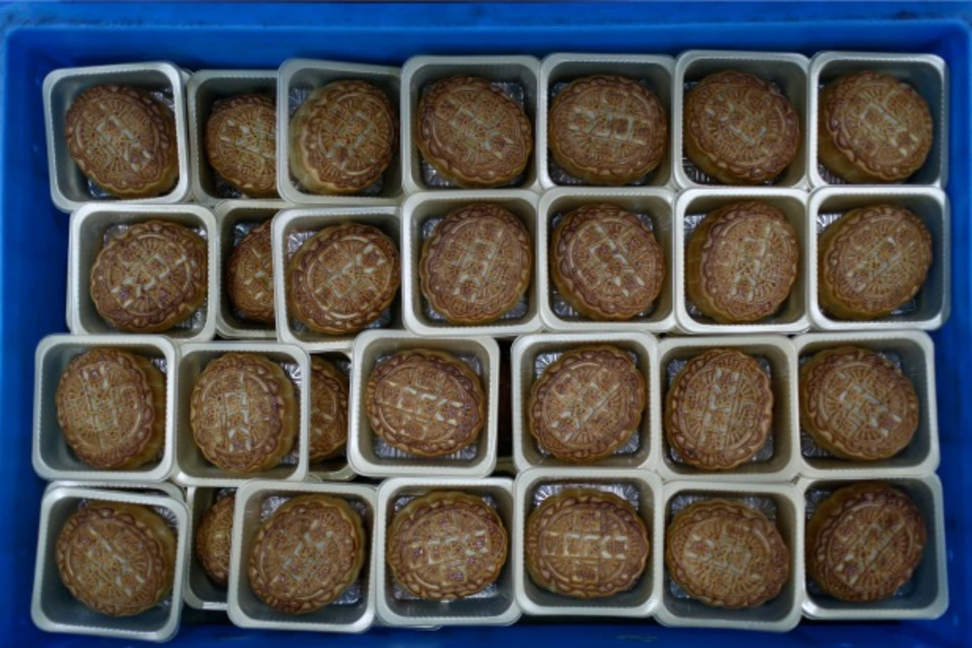 <p>Freshly-baked mooncakes pass along a conveyor belt at a mooncakes factory in Shanghai on September 12, 2013. (Aly Song/Courtesy Reuters)</p>