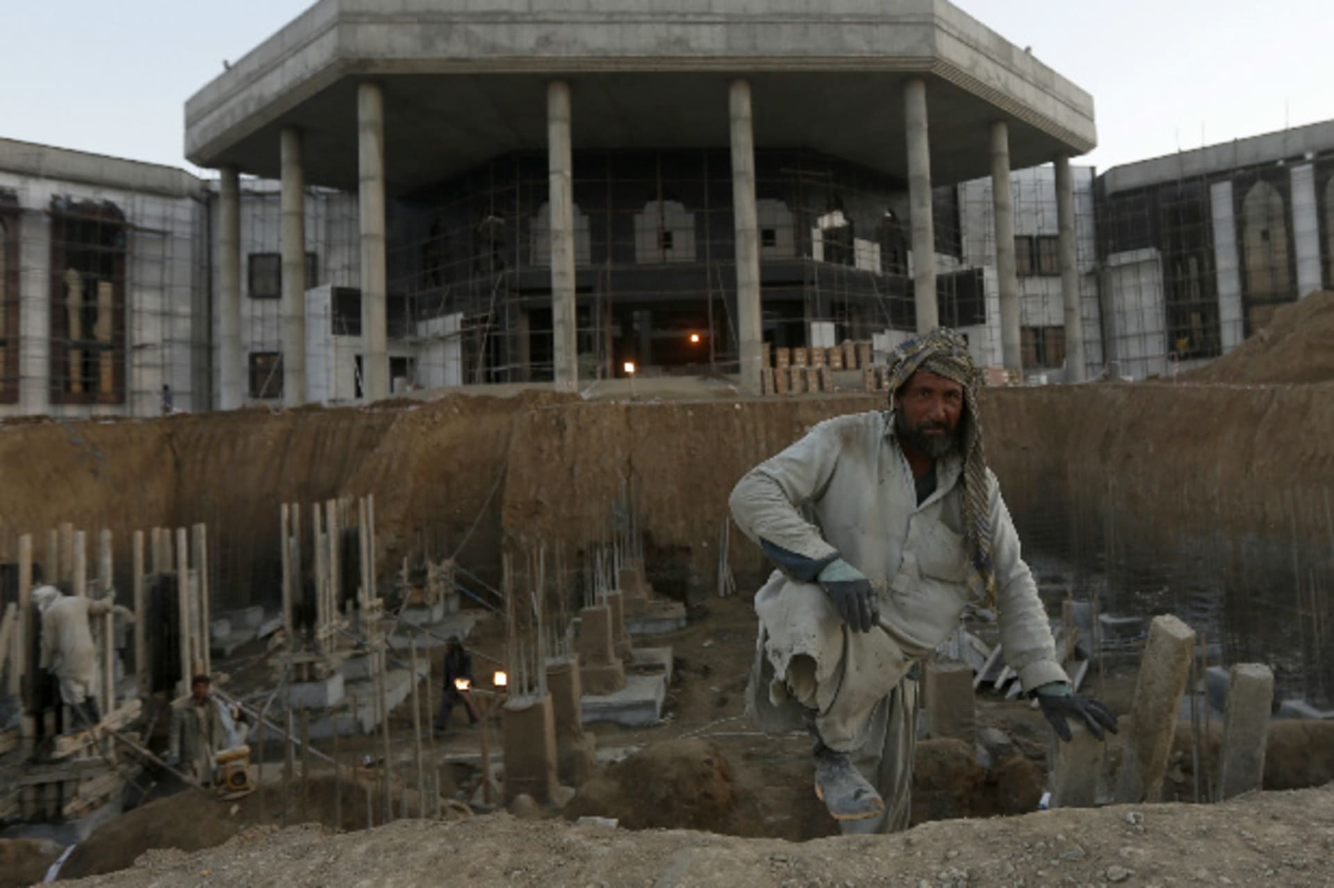 <p>Afghans work at a new parliament building constructed by an Indian project in Kabul on November 26, 2013 (Mohammad Ismail/Courtesy: Reuters).</p>
