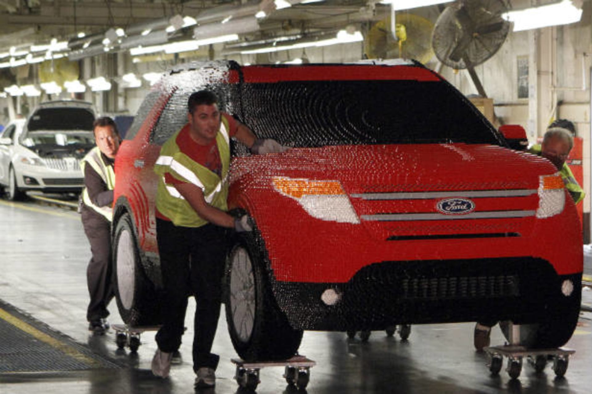<p>Workers from Ford’s Chicago Assembly Plant push a full-size Legoland edition Ford Explorer, made with more than 380,000 Lego blocks. (Frank Polich/courtesy Reuters)</p>