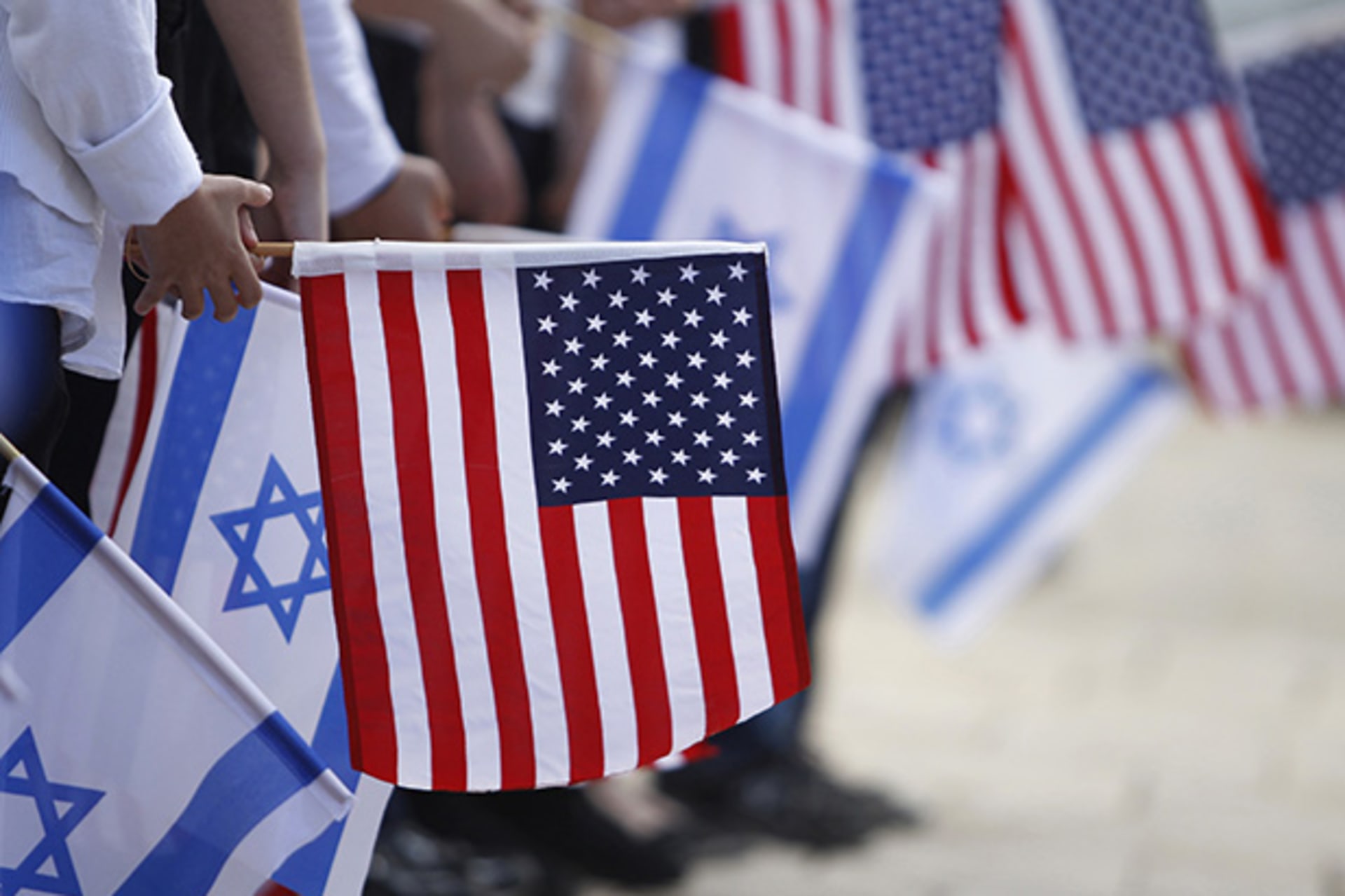 Israeli schoolchildren hold the Israeli and American flags during a rehearsal for Obama's visit at Peres' residence tomorrow, in Jerusalem