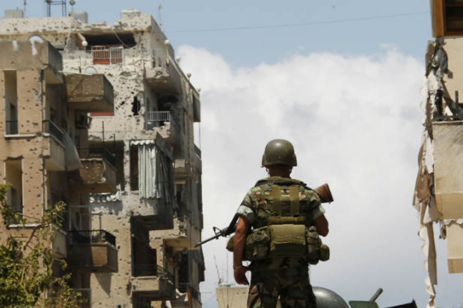 A Lebanese army soldier stands atop of an armoured personnel carrier as he patrols the area near the mosque complex where hardline Sunni cleric Sheikh Ahmed al-Assir was believed to be sheltering with his supporters, in Abra near Sidon, souther