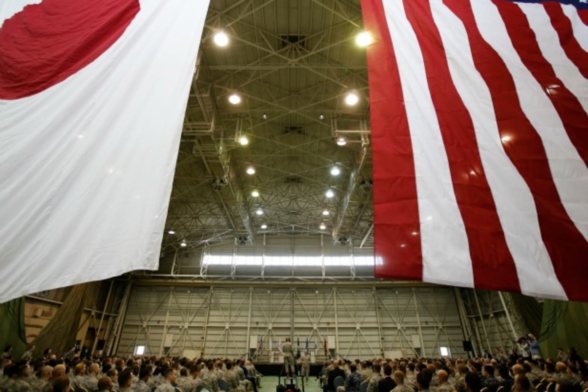 <p>U.S. Chairman of the Joint Chiefs of Staff Army Gen. Martin Dempsey (centre R) stands below flags of Japan (L) and the U.S. as he talks to U.S. military personnel stationed at Yokota Air Base in Tokyo on April 25, 2013. (Courtesy Reuters/Yuya Shino)</p>
