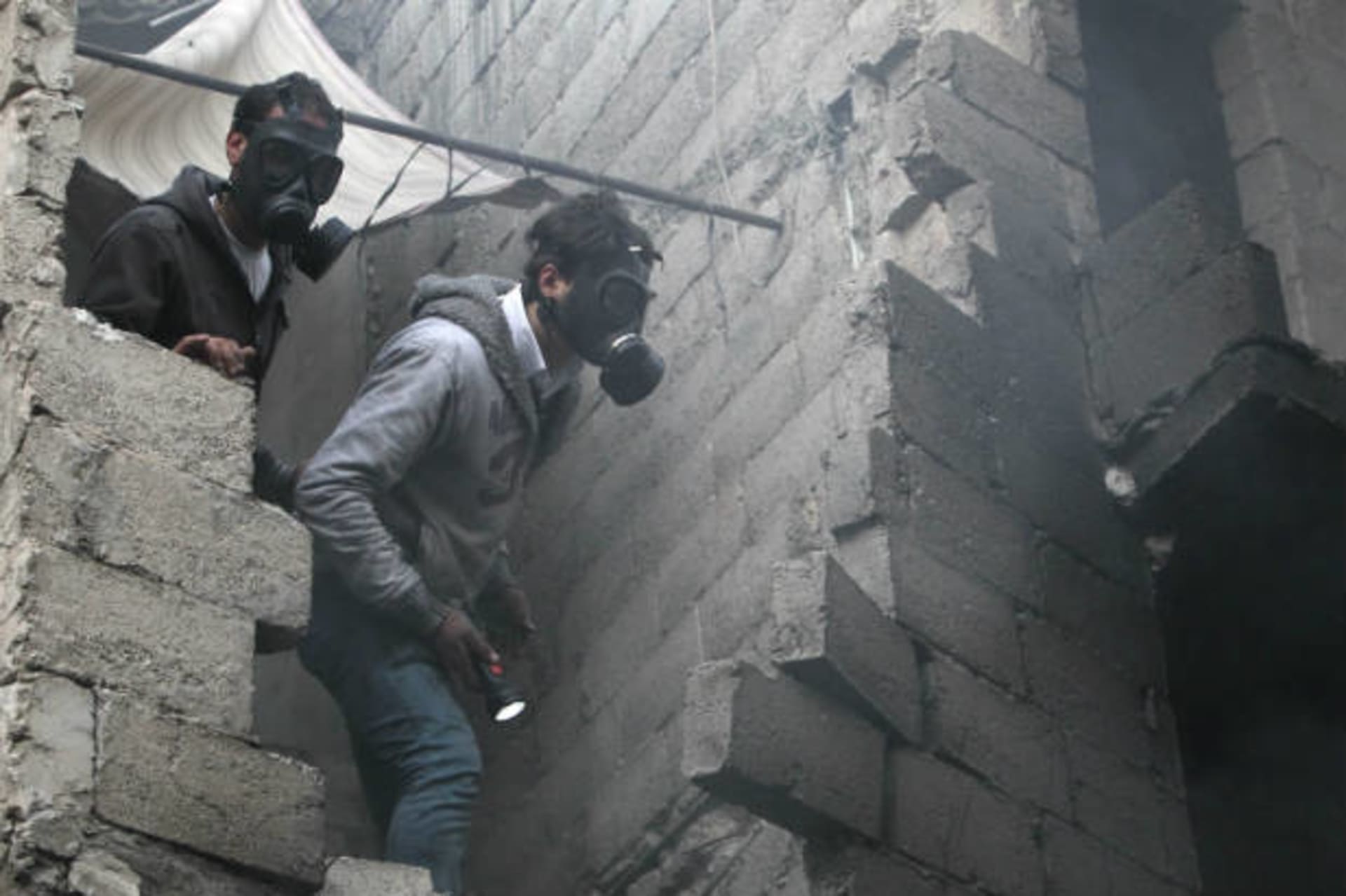Residents wear masks as they search for bodies in Aleppo (Salman/Courtesy Reuters).