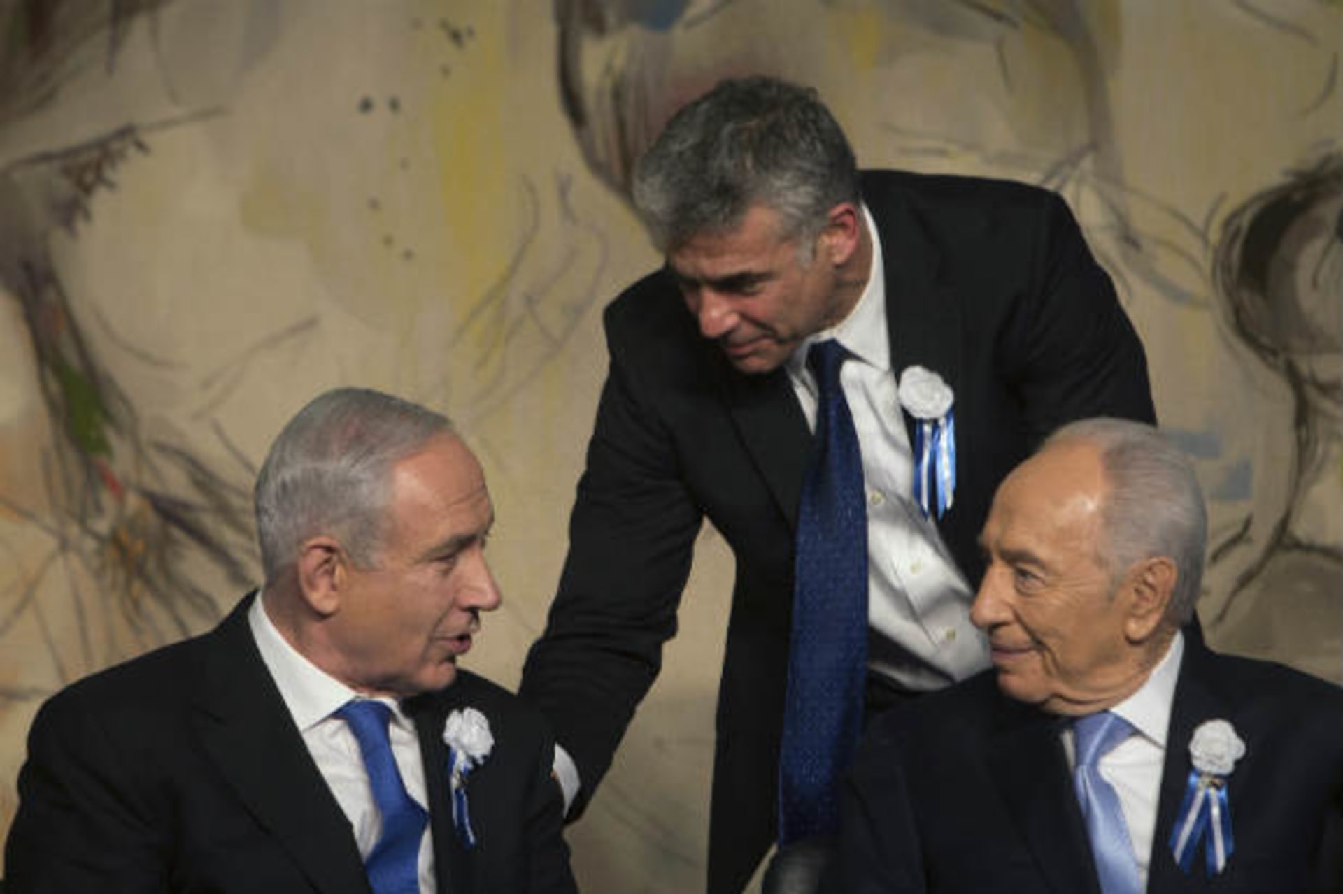 Yair Lapid, head of Yesh Atid party stands behind Israel's prime minister Benjamin Netanyahu and president Shimon Peres at a reception following the swearing-in ceremony of the 19th Knesset, the new Israeli parliament, in Jerusalem February 5,