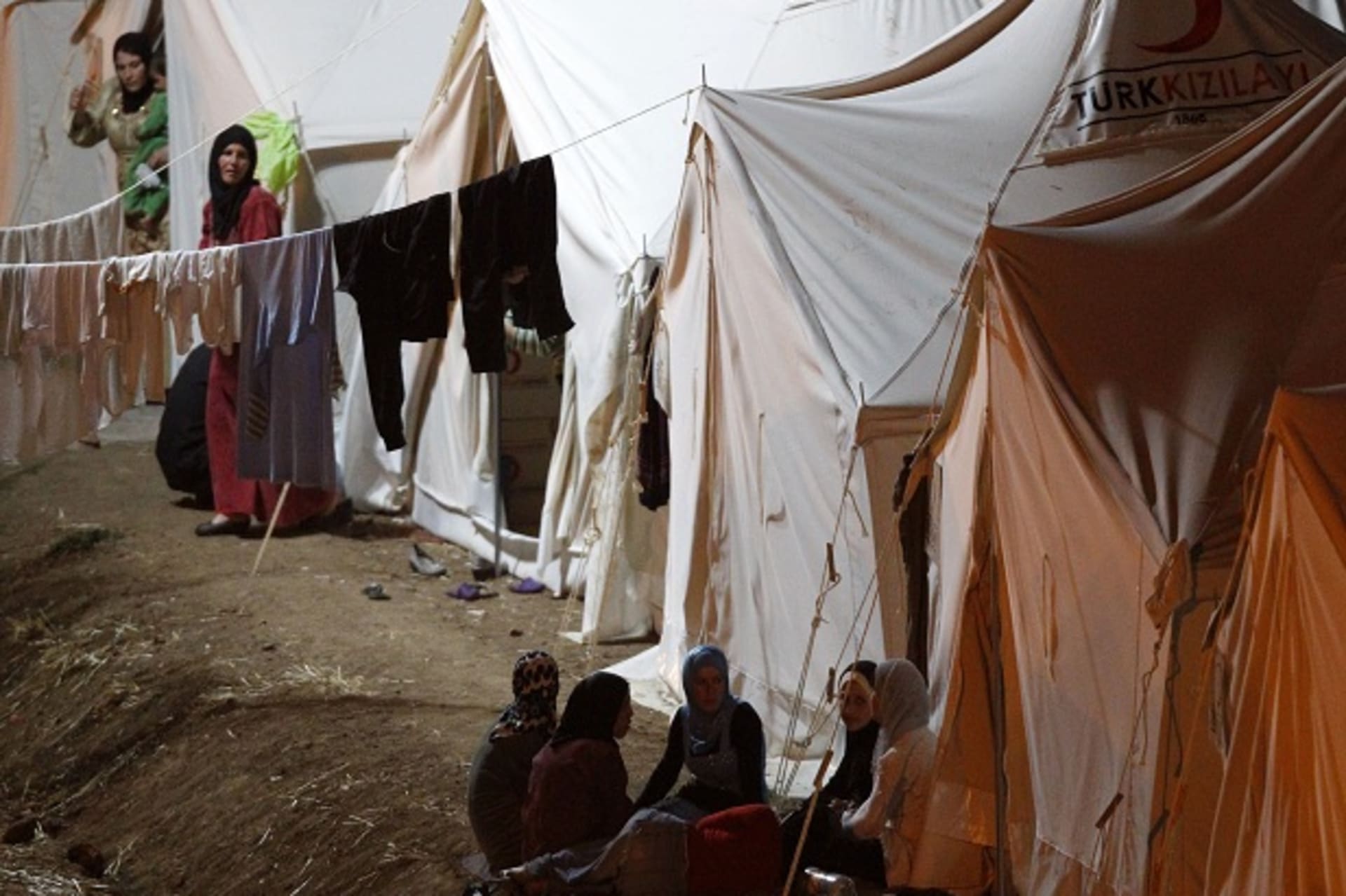 Syrian refugees chat as they spend time at a refugee camp in the Turkish border town of Yayladagi in Hatay province