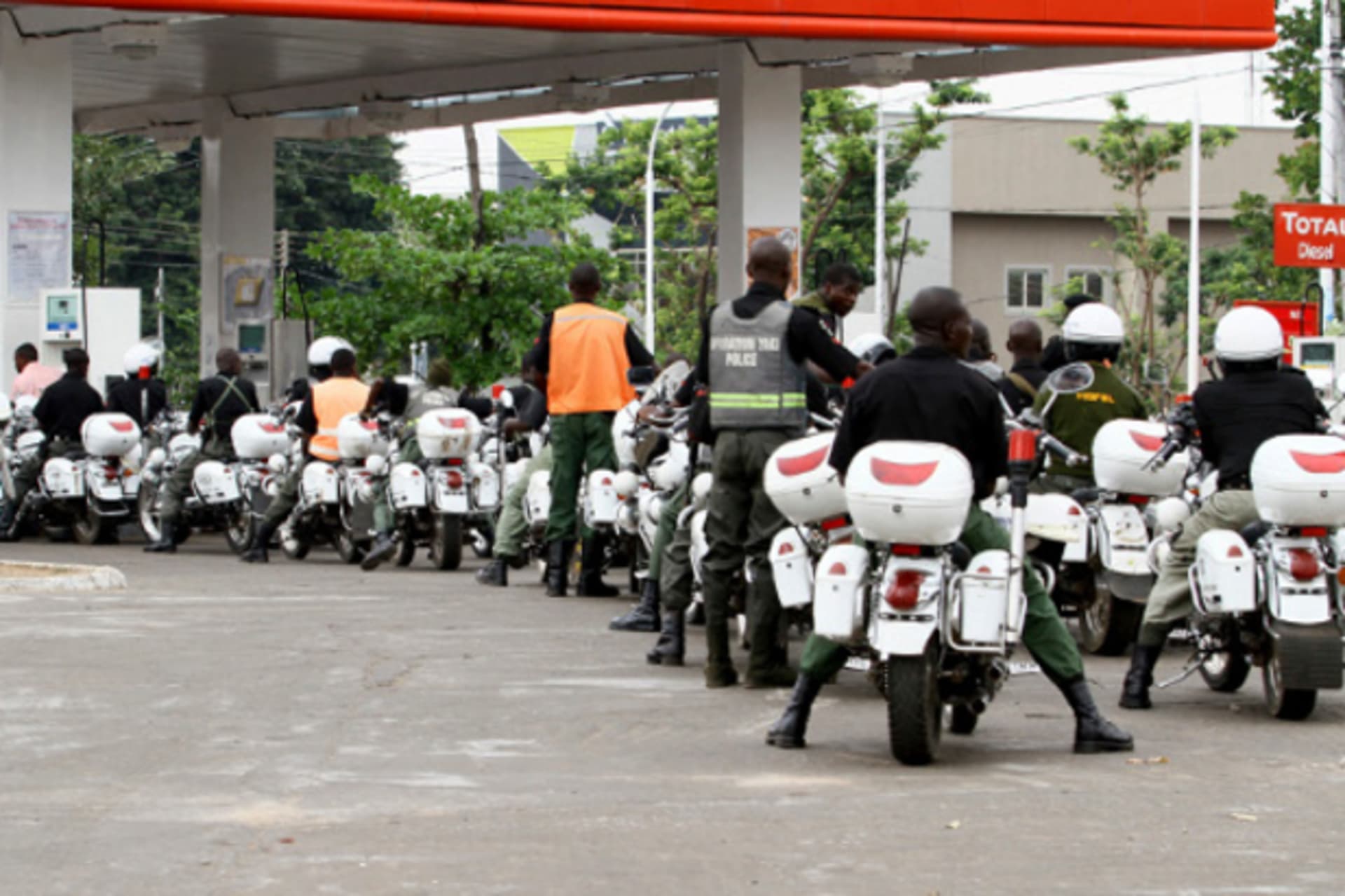 Police queue at a petrol station to pump their motorcycles with fuel before the start of the governorship election in Nigeria's northern state of Kaduna April 28, 2011.