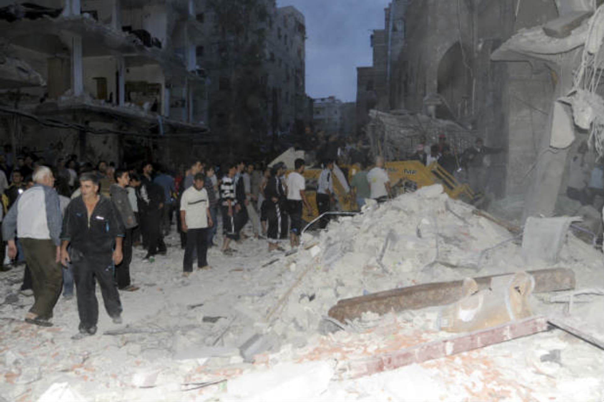 A crowd gathers in front of damaged buildings after a car bomb exploded in Damascus hours after the ceasefire went into place on October 26, 2012 (Courtesy Reuters).