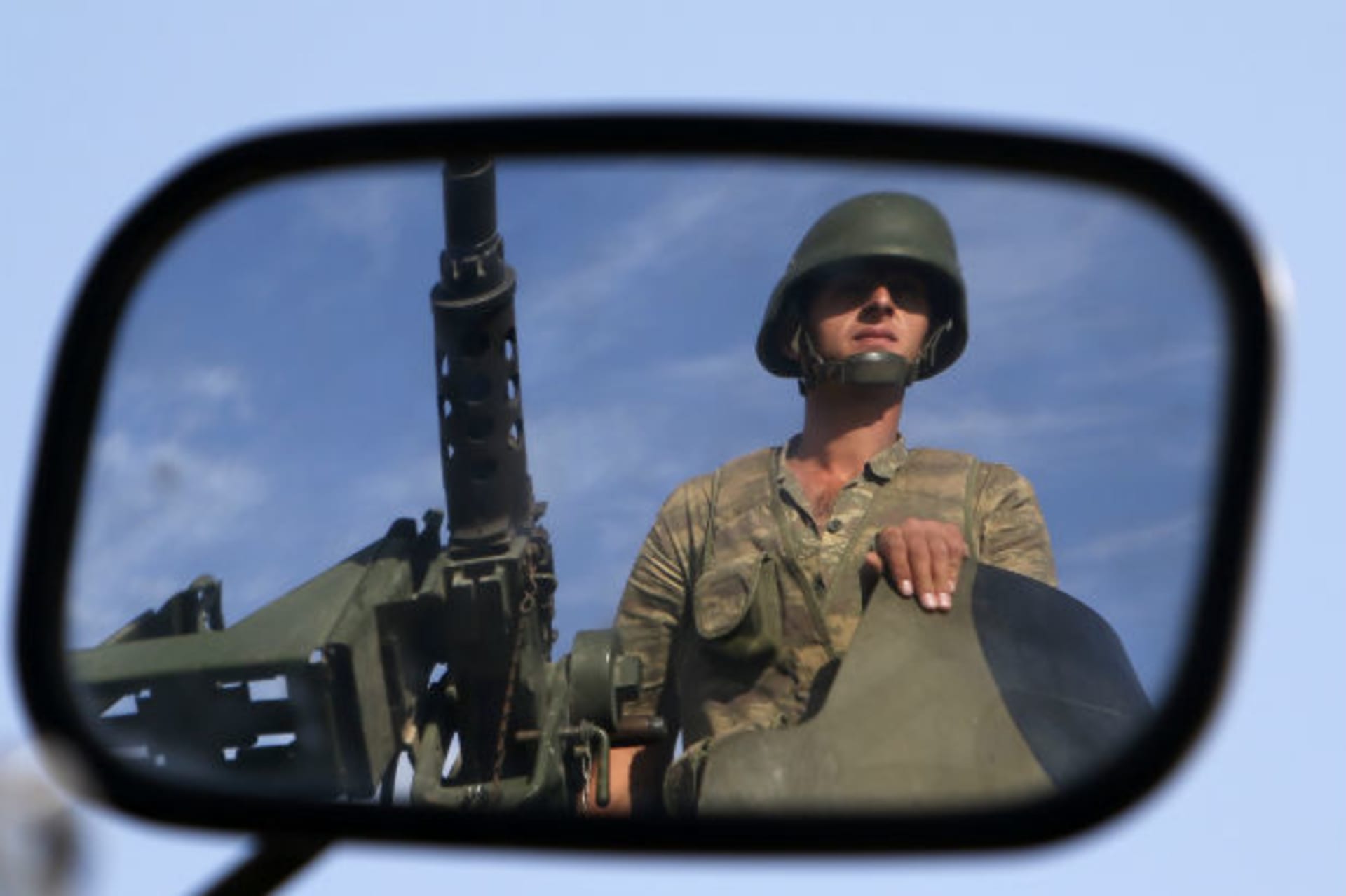 A Turkish soldier is reflected on a mirror as he stands guard on the Turkish-Syrian border near the Akcakale border crossing on October 4, 2012 (Sezer/Courtesy Reuters).