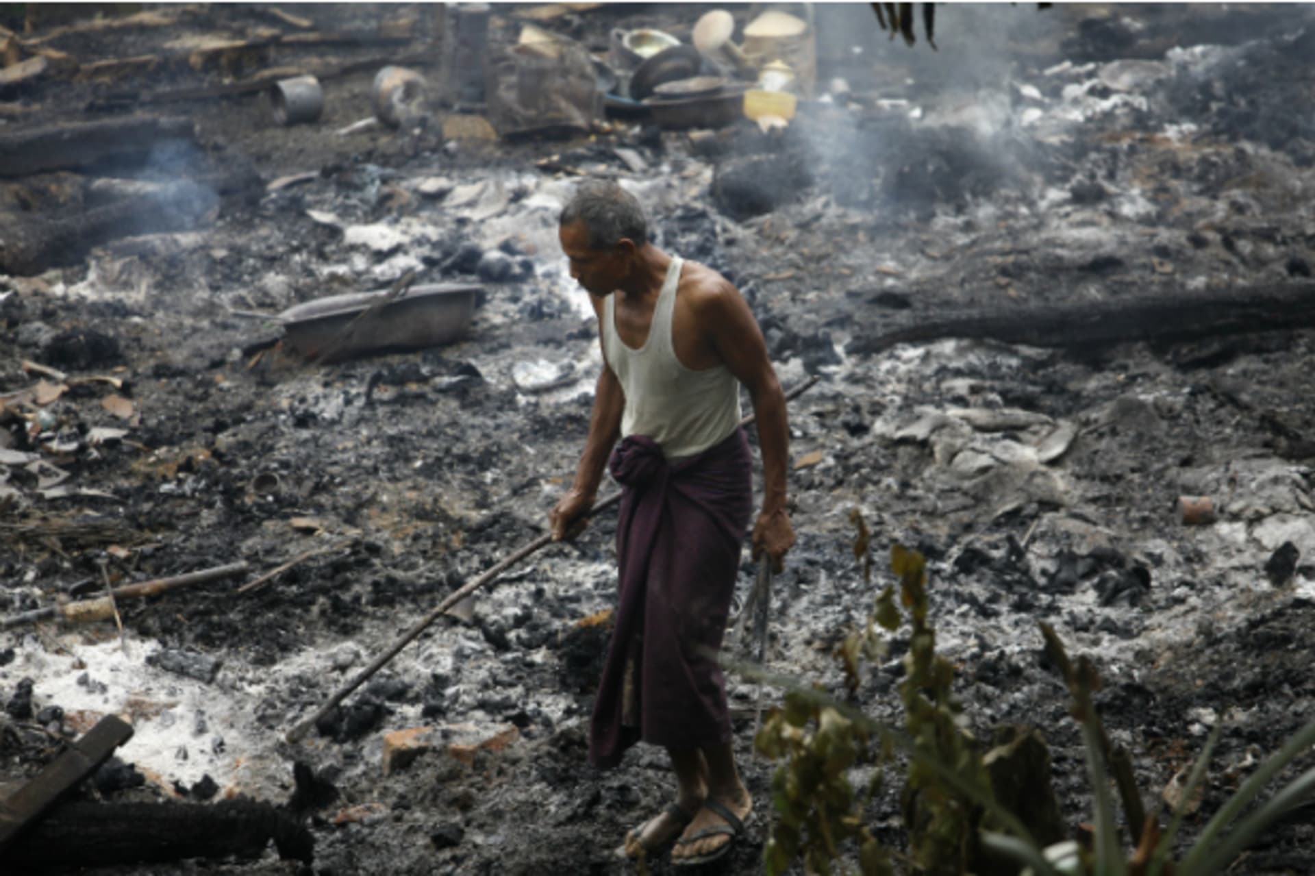 <p>A Muslim man searches for his belongings left behind of his burnt home at Thapyuchai village, outside of Thandwe in the Rakhine state, on October 2, 2013. (Soe Zeya Tun/Courtesy Reuters)</p>
