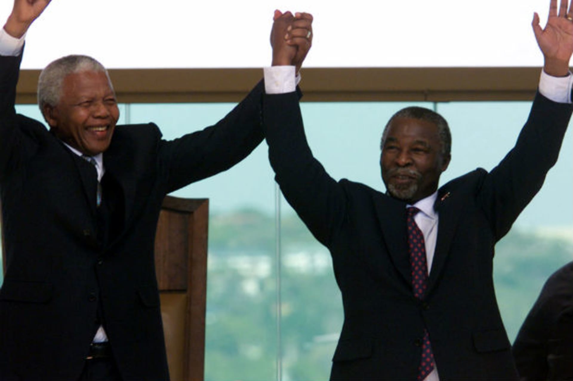 Former South African President Nelson Mandela (L) raises the hand of the new President, Thabo Mbeki after he took the oath of office at the Union Buildings in Pretoria June 16.