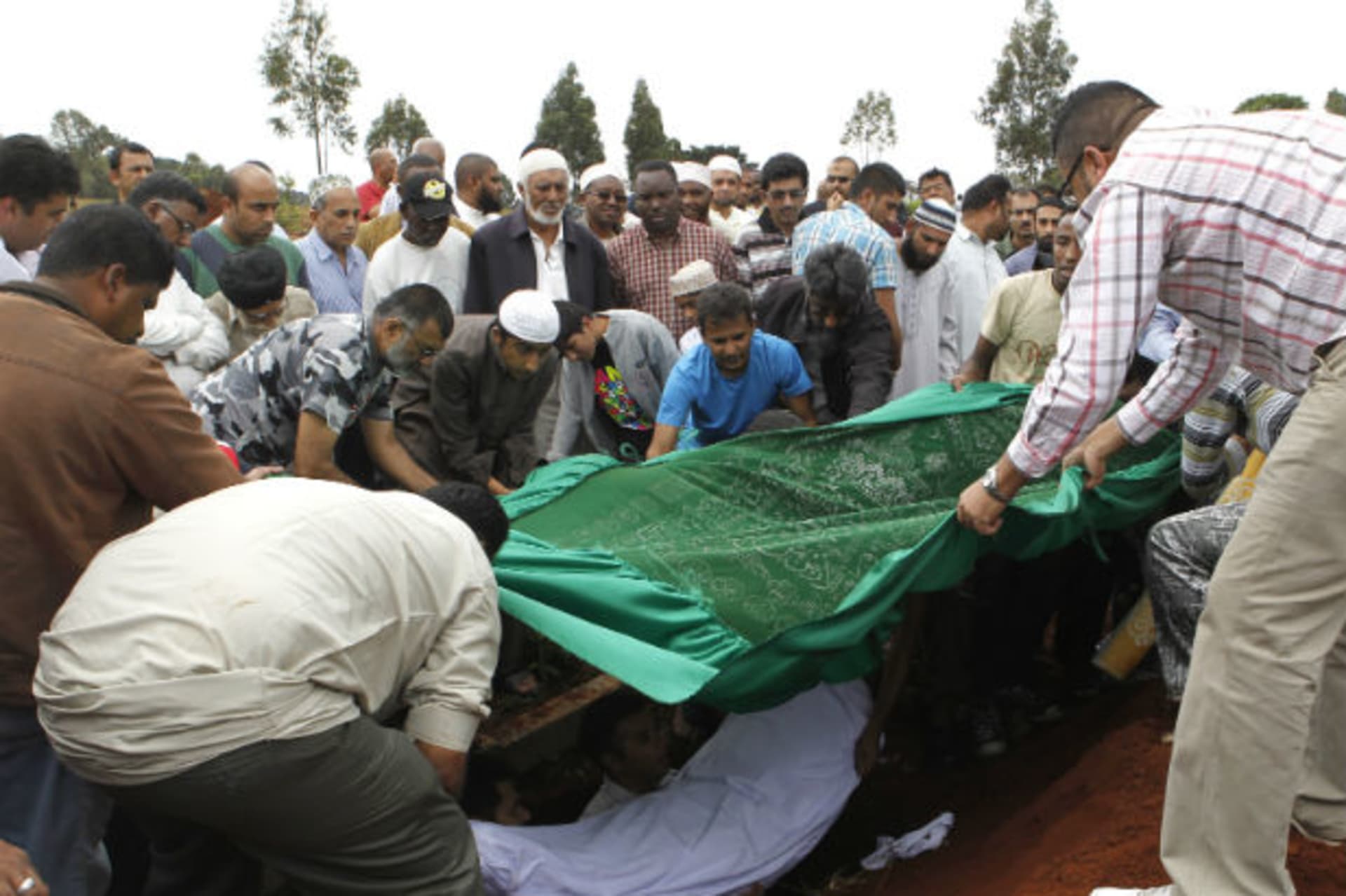 Relatives and Muslim faithful bury the slain body of Rehmad Mehbub, 18, who was killed in a crossfire between armed men and the police at the Westgate shopping mall, in Kenya's capital Nairobi September 22, 2013.