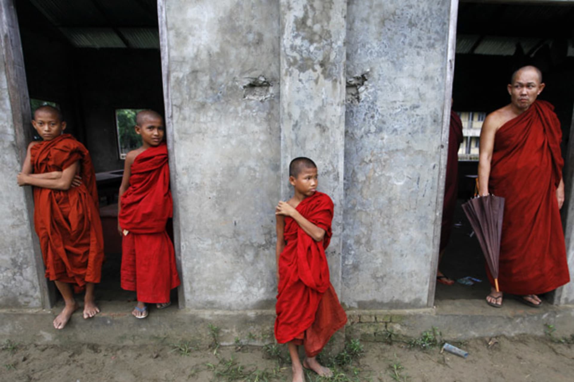 <p>Buddhist novice monks look from a monastery during fighting between Buddhist Rakhine and Muslim Rohingya communities in Rakhine State.</p>
