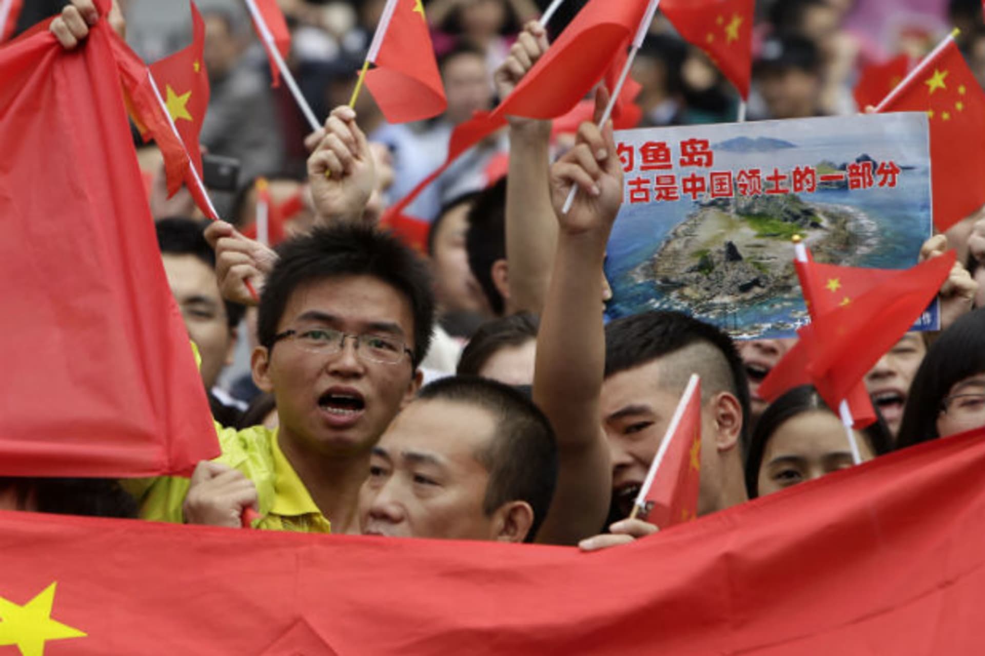 <p>Protesters hold Chinese national flags and a poster showing the disputed Islands, called Senkaku by Japan and Diaoyu by China, on the 81st anniversary of Japan’s invasion of China, in Chengdu.</p>
