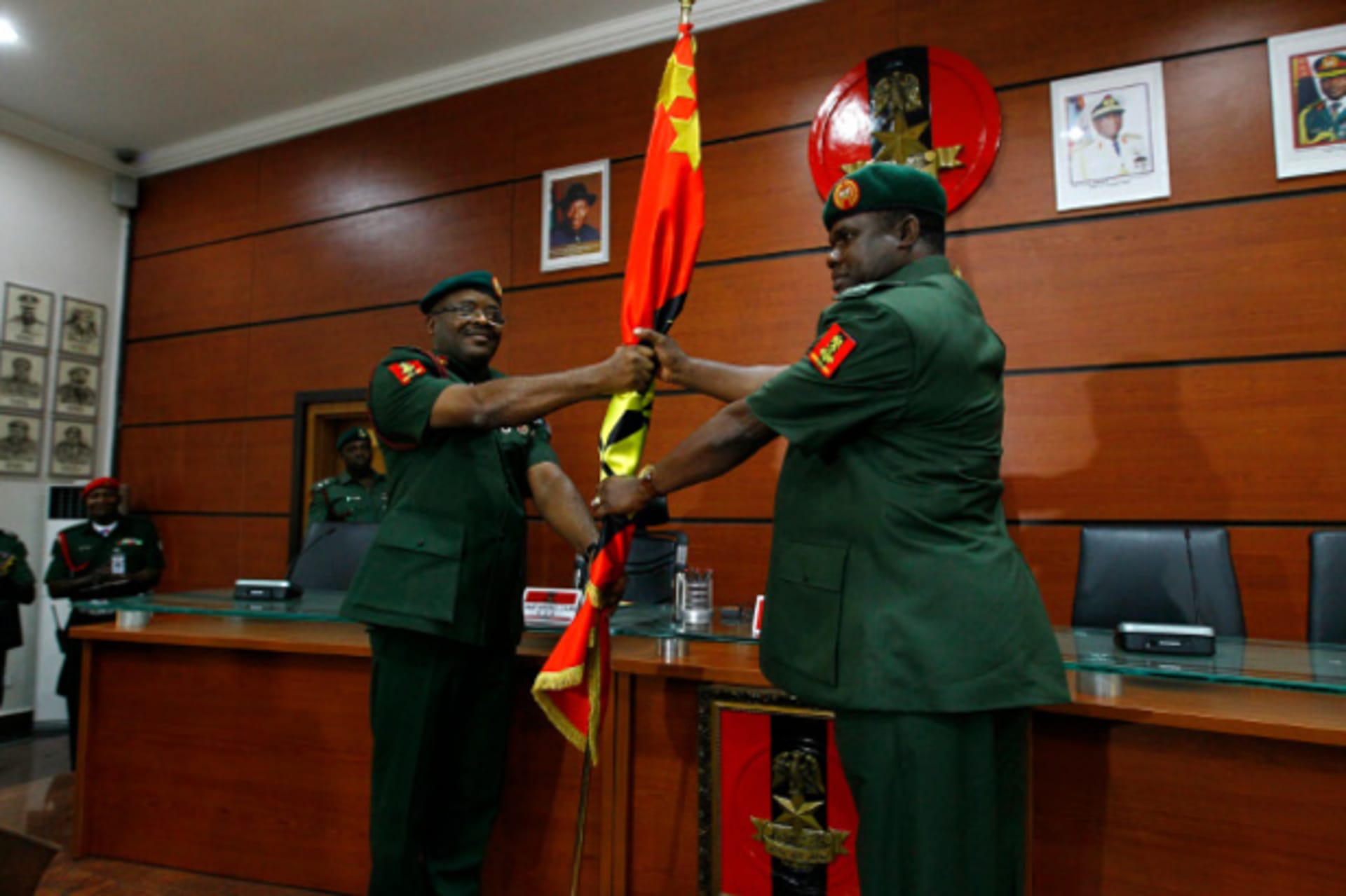 Lieutenant-General Azubike Ihejirika (L) presents a flag to the new Chief of Army Staff, Major-General Kenneth Tobiah Jacob Minimah, during a handing over ceremony at the Defence Ministry headquarters in Abuja January 20, 2014.