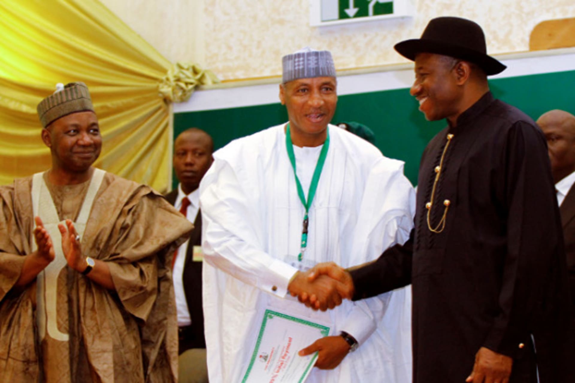 Nigeria's President Goodluck Jonathan (R) shakes hands with Muhammad Tukur Modibbo, managing director of Aura Energy Ltd, as Vice President Namadi Sambo (L) applauds during the Presidential Power Reform Transactions signing ceremony in Abuja Ap