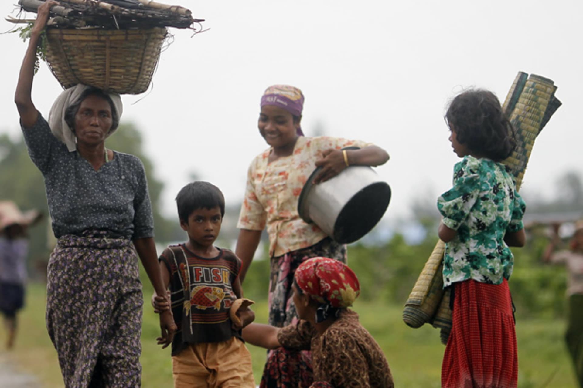 <p>Rohingya Muslims carry their belongings as they move after recent violence in Sittwe June 16, 2012.</p>
