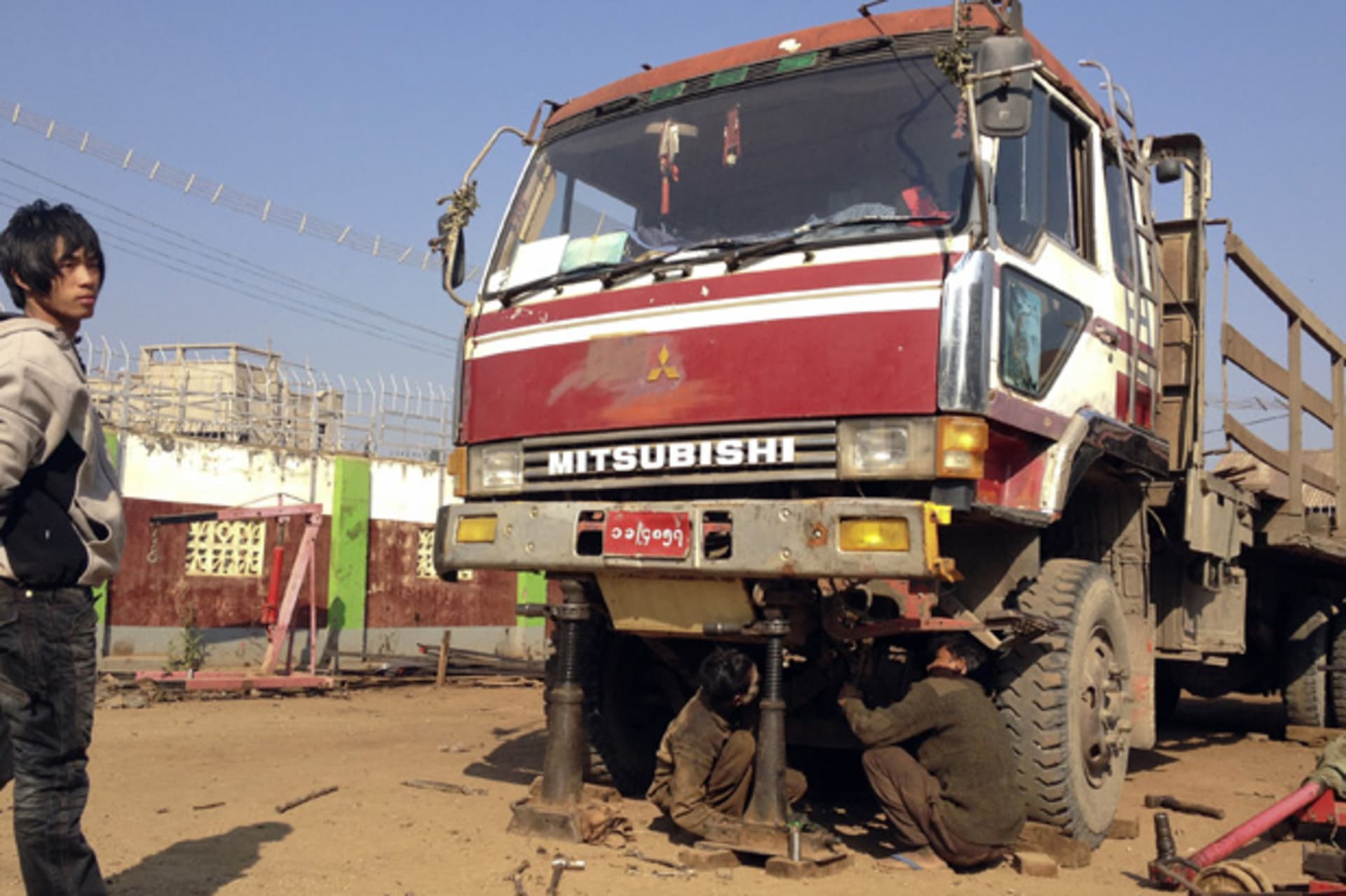 <p>Workers in Myanmar mend a truck used to carry goods to and from China in the northeastern town of Lashio January 19, 2012.</p>
