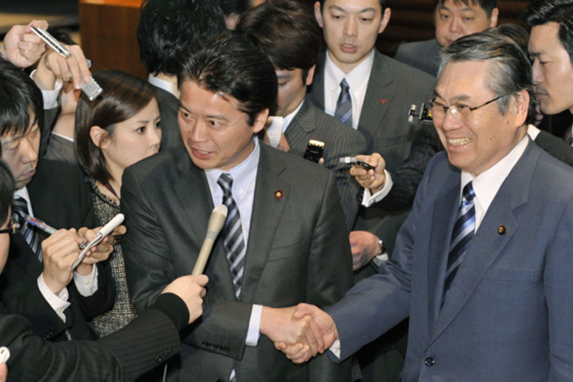 <p>Japan’s Foreign Minister Koichiro Gemba shakes hands with Defence Minister Naoki Tanaka as they are surrounded by media in Tokyo</p>
