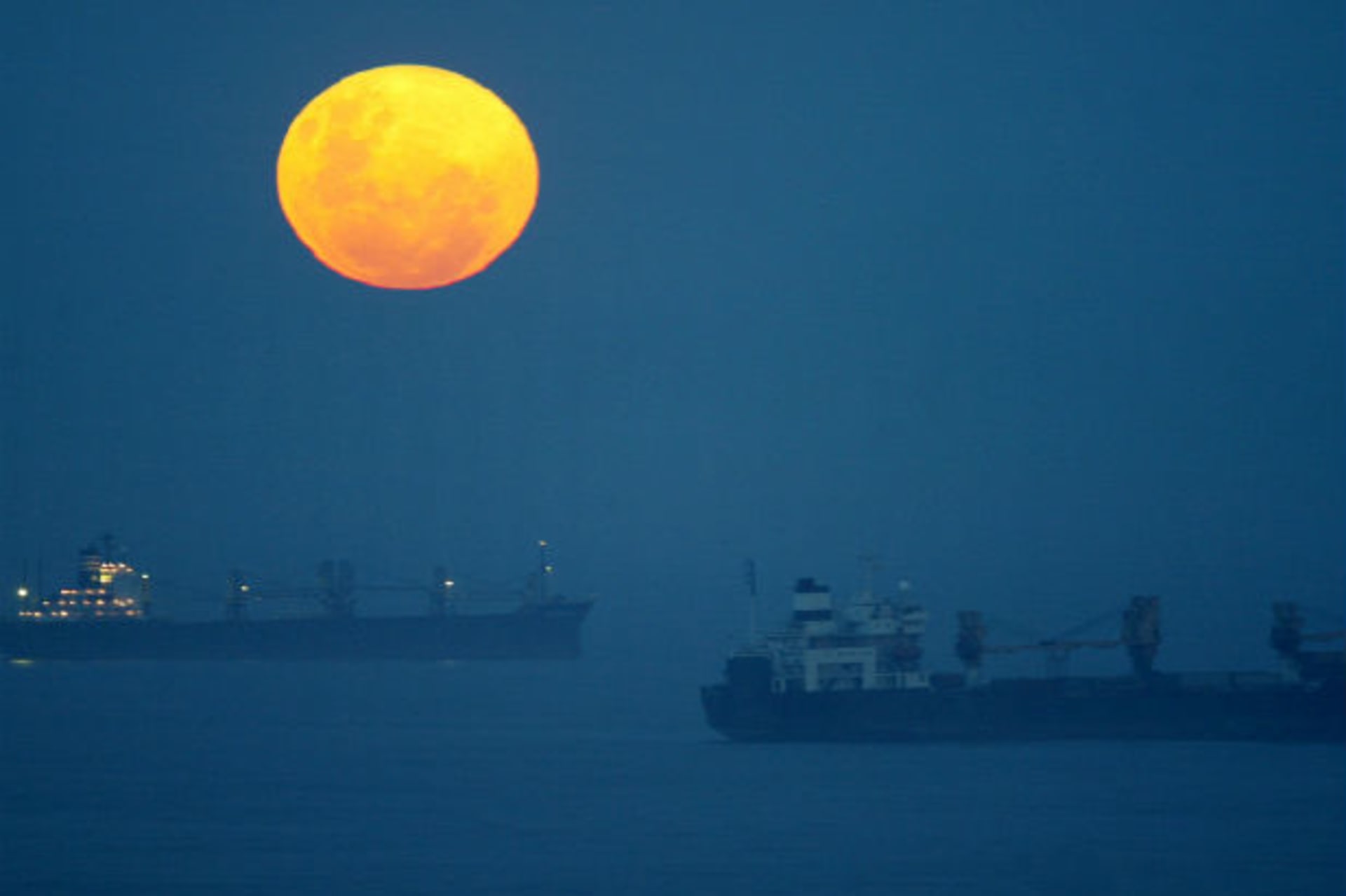 Ships lie at anchor outside the harbour at Durban, South Africa as a full moon rises on Boxing Day December 26, 2004.