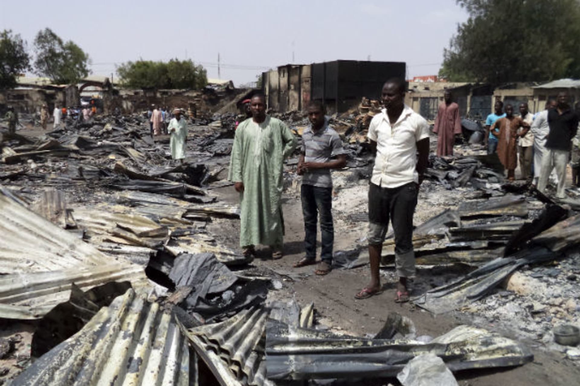 People gather around the ruins of the burnt Bama Market, which was destroyed by gunmen in last Thursday's attack, in Maiduguri, northeast Nigeria April 29, 2013.