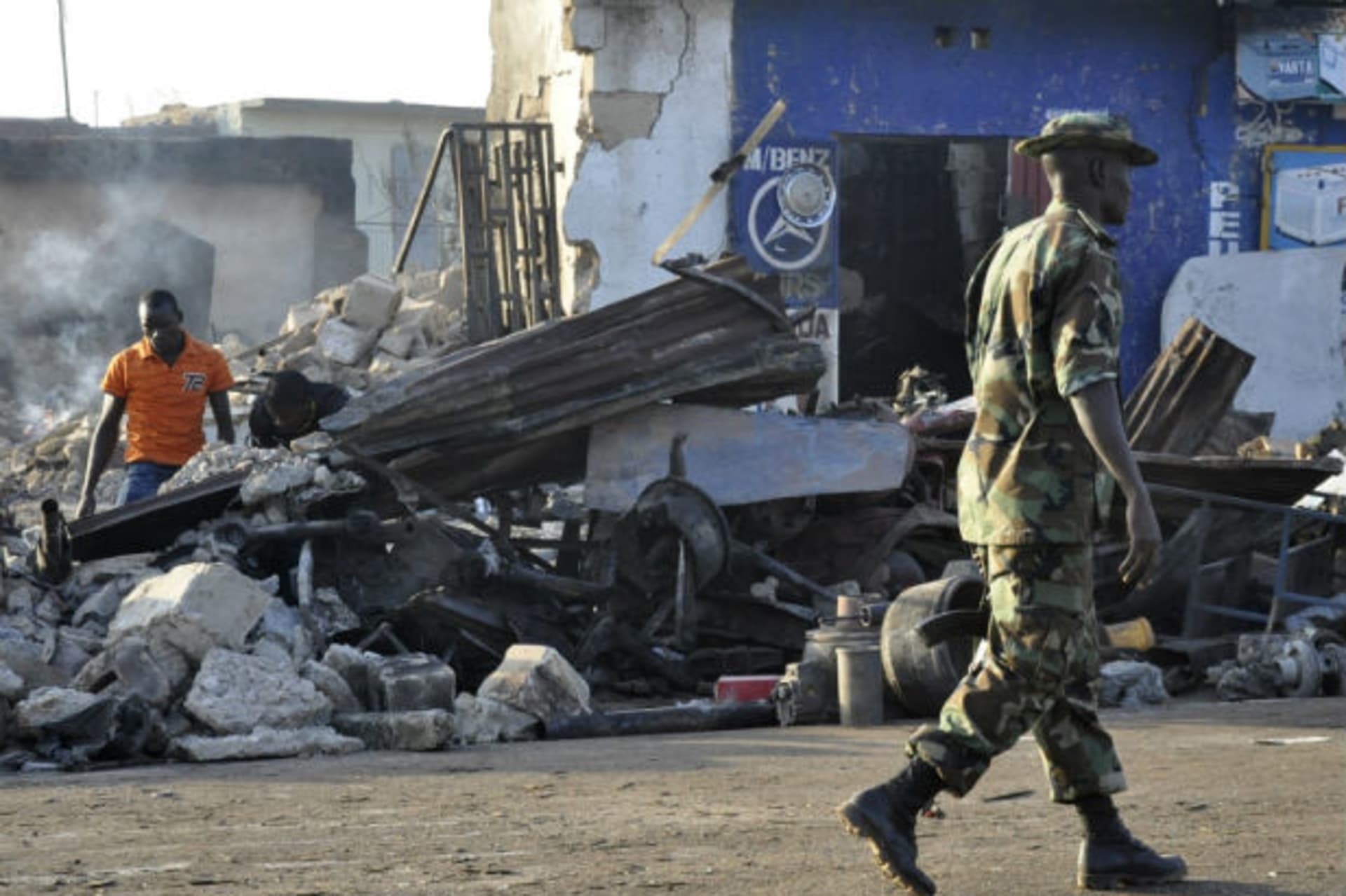 A soldier walks past the scene of a bomb explosion in Nigeria's northern city of Kaduna December 7, 2011.