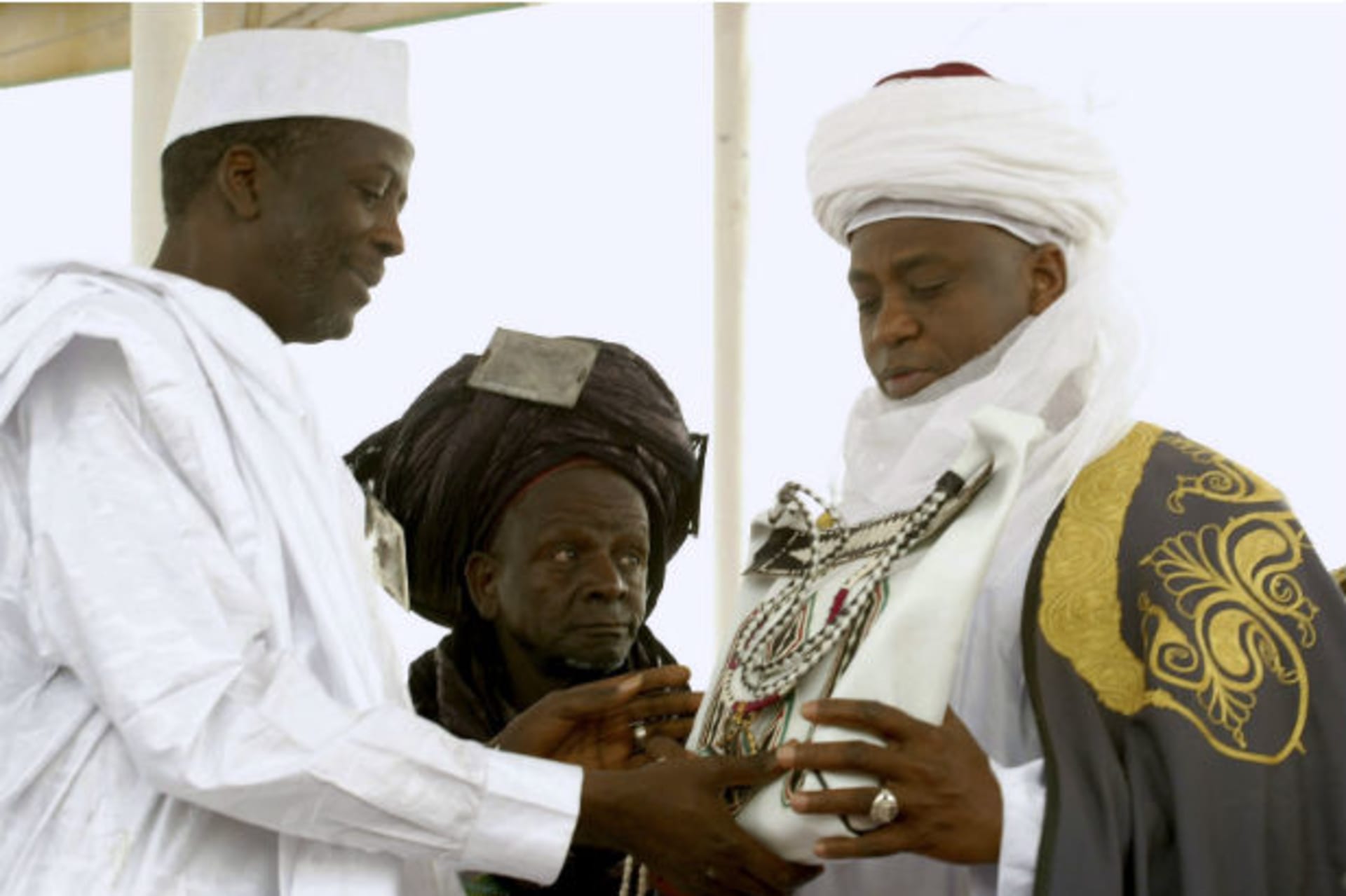 The new Sultan of Sokoto, Saad Abubakar,(C) the spiritual leader of Nigeria's Muslims, receives a copy of the Qura'an from Sokoto state governor Atahiru Bafarawa, during a coronation ceremony in Sokoto March 3, 2007.