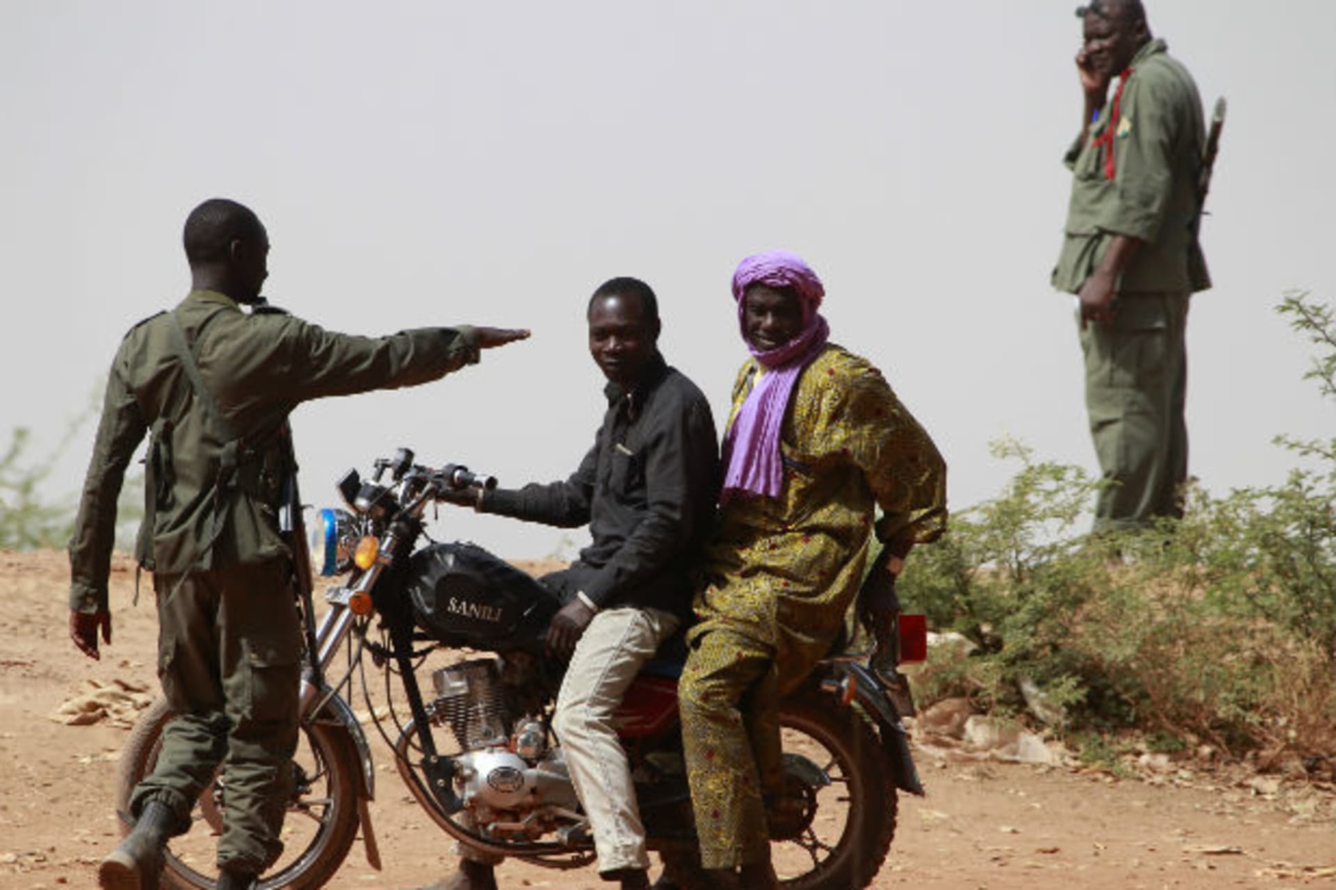 A Malian soldier checks two civilians in the recently liberated town of Diabaly 24/01/2013.