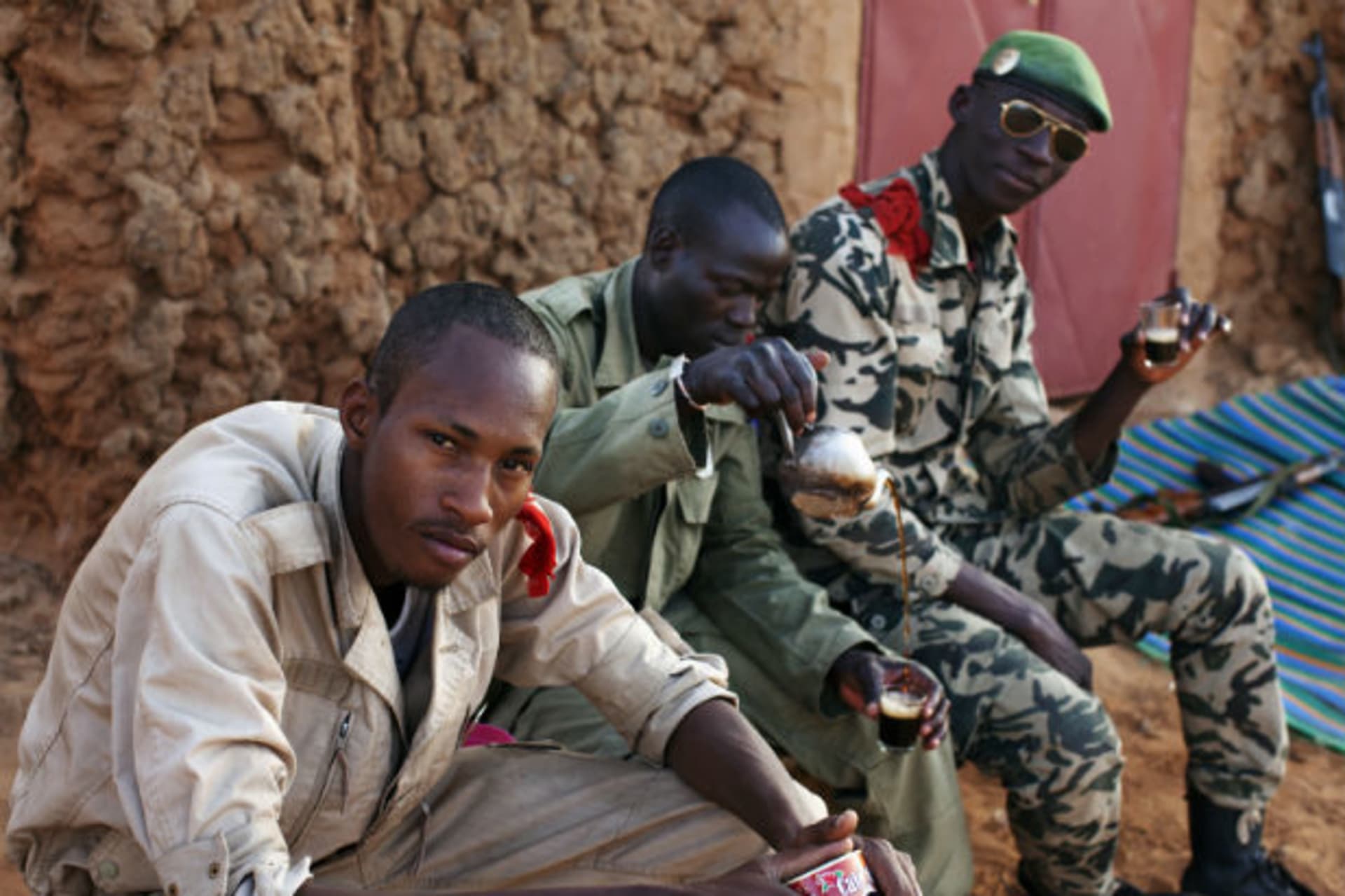 Malian soldiers sit together as they drink coffee at a checkpoint in Gao March 4, 2013.