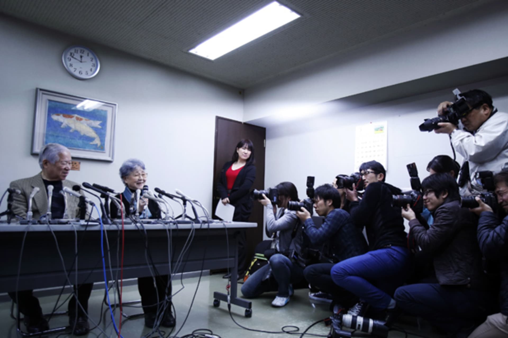 <p>Photographers take pictures of Shigeru Yokota (L) and his wife Sakie (C), parents of Megumi Yokota who was abducted by North Korea agents at age 13 in 1977, during a news conference in Kawasaki, west of Tokyo, March 17, 2014</p>
