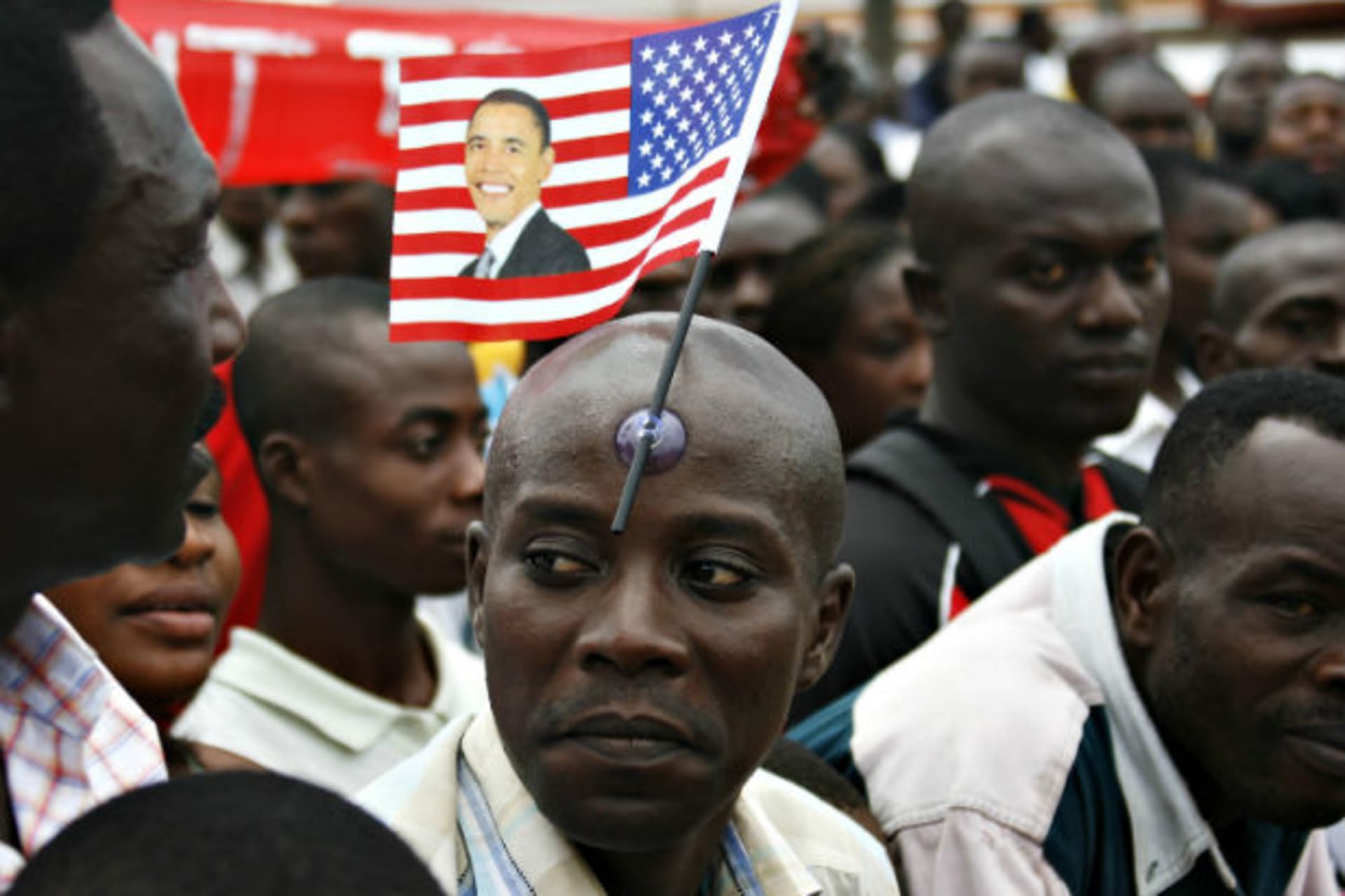 A man with a flag stuck to his forehead waits to catch a glimpse of U.S. President Barack Obama in Accra 11/07/2009.