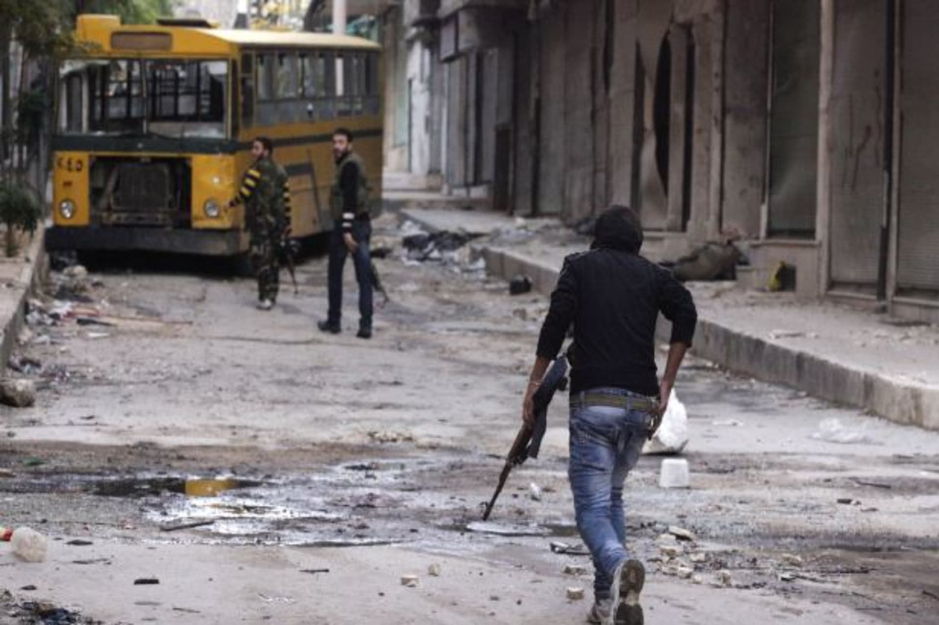 <p>A Free Syrian Army fighter runs for cover in Aleppo (Stringer/Courtesy Reuters).</p>
