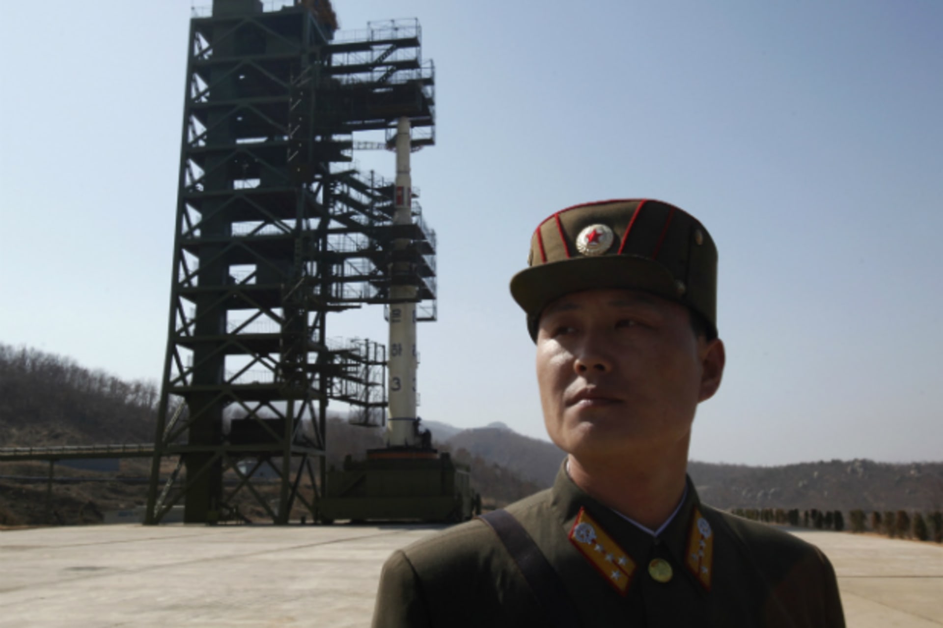 <p>A soldier stands guard in front of the Unha-3 (Milky Way 3) rocket sitting on a launch pad at the West Sea Satellite Launch Site, during a guided media tour by North Korean authorities in the northwest of Pyongyang. (Bobby Yip/Courtesy Reuters)</p>
