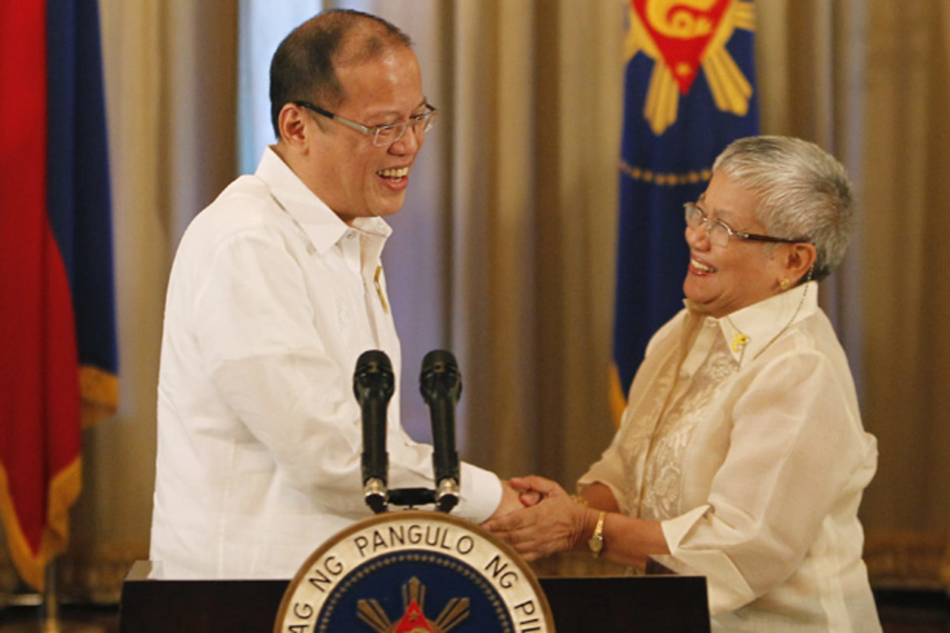 <p>Philippine president Benigno Aquino shakes hands with presidential adviser on the peace process, Secretary Teresita Quintos-Deles, after his speech on national television at the Malacanang palace in Manila October 7, 2012.</p>
