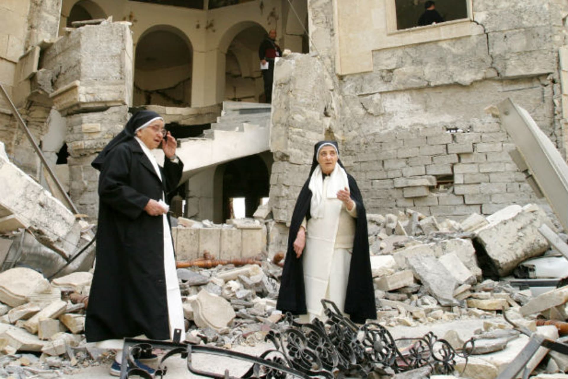 Iraqi nuns survey destruction to church in northern Iraq (Courtesy Reuters).