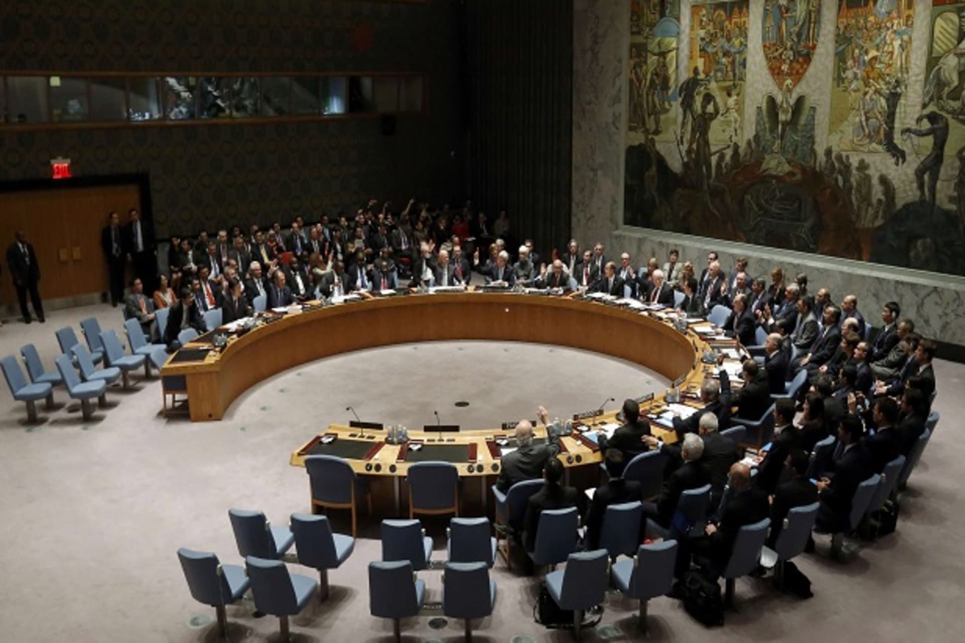 Members of the United Nations Security Council raise their hands as they vote unanimously to approve a resolution eradicating Syria's chemical arsenal in New York