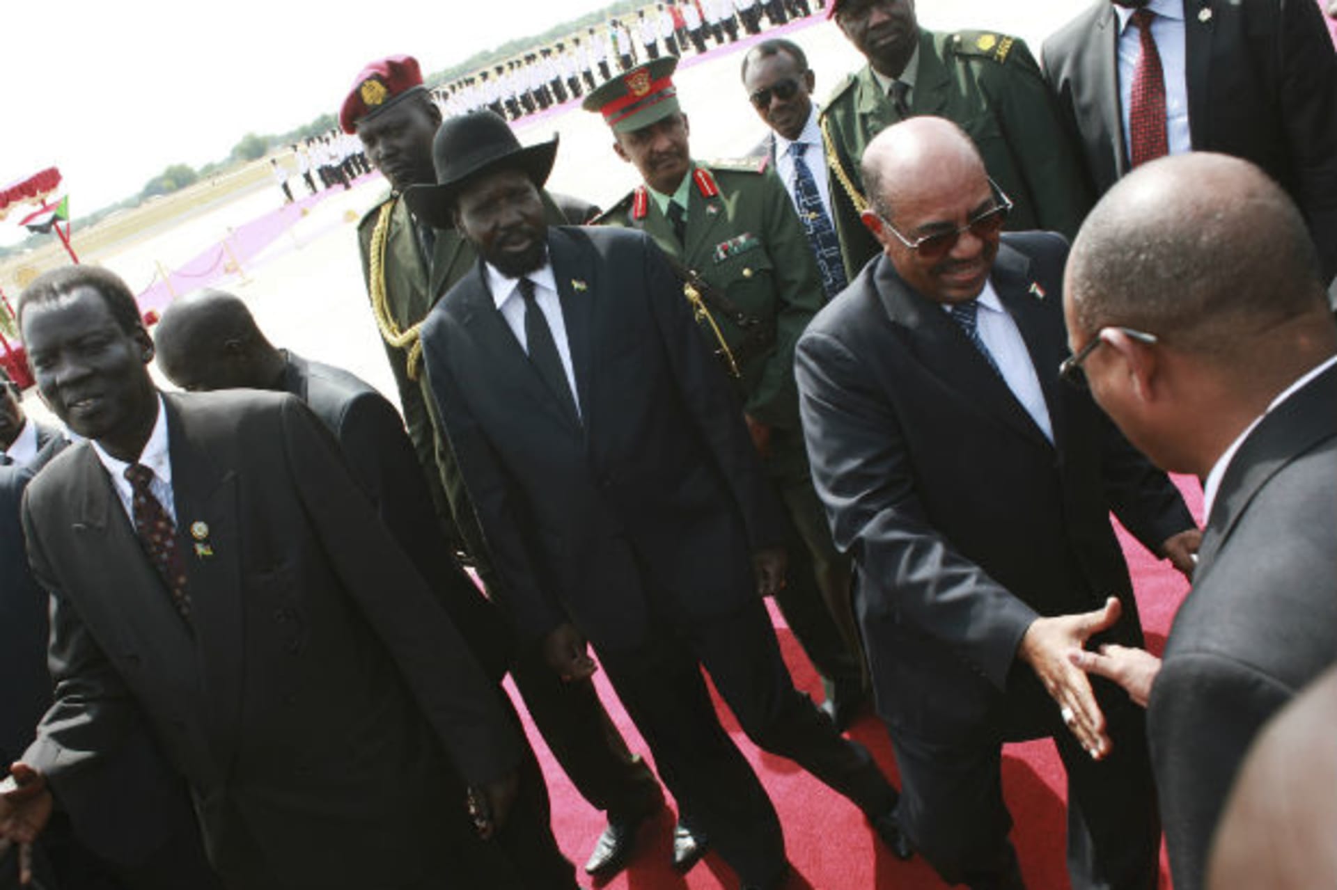 Sudan's President Omar Hassan al-Bashir (2nd R) meets officials from the Government of South Sudan (GOSS) near his South Sudan counterpart Salva Kiir (C) upon his arrival at the Juba Airport in South Sudan April 12, 2013.