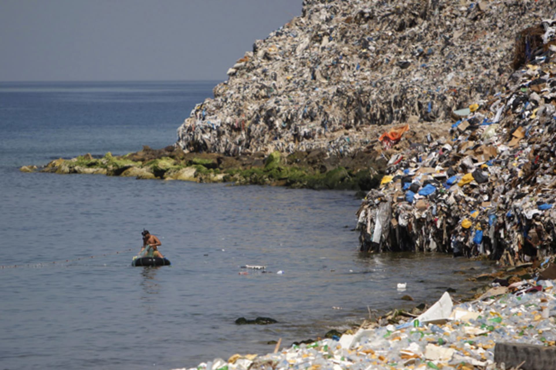 A fisherman is seen near a rubbish dump on the Sidon seafront in south Lebanon