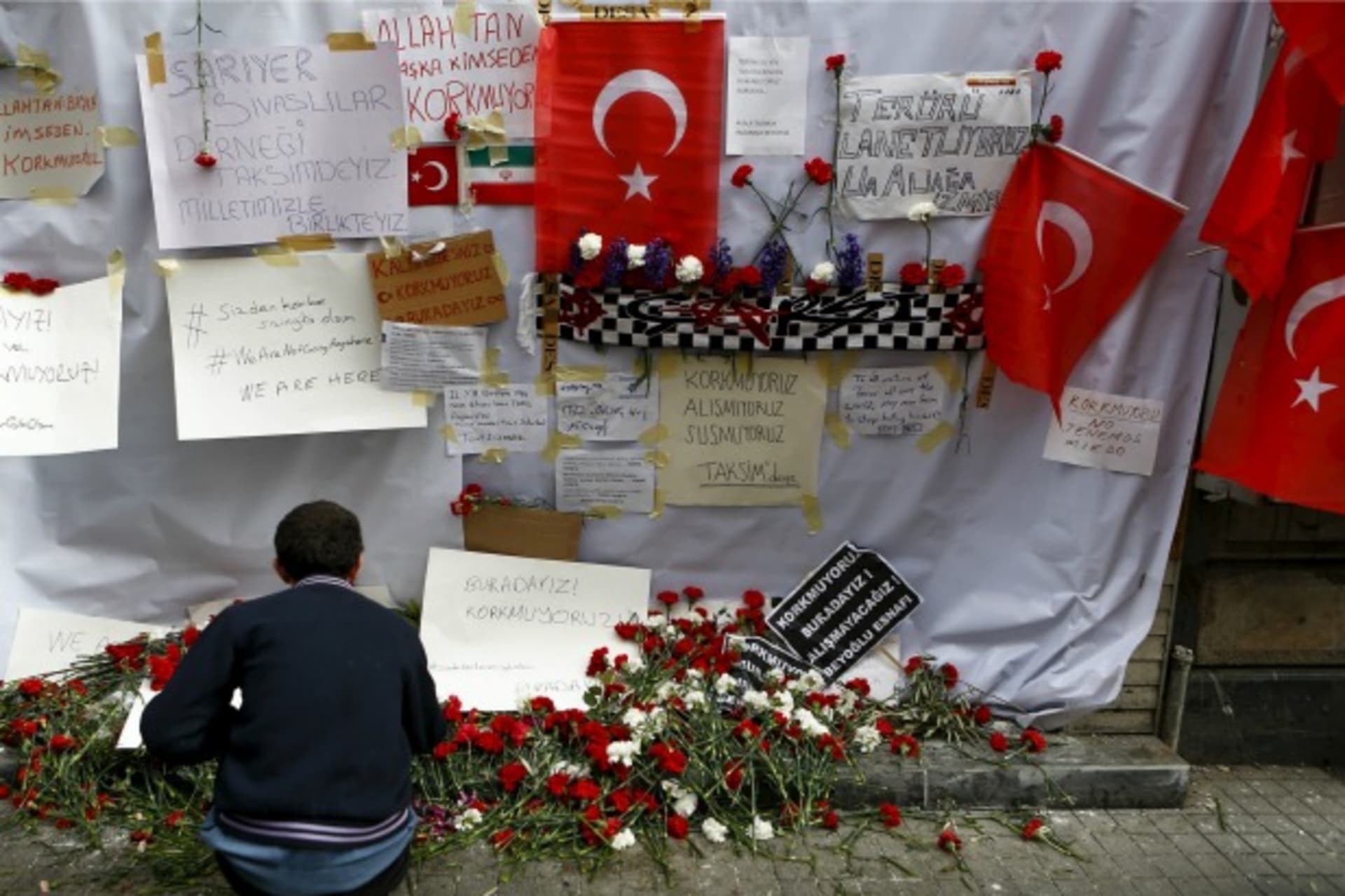 <p>A man places carnations at the scene of a suicide bombing at Istiklal street, a major shopping and tourist district, in central Istanbul, Turkey (Osman Orsal/Reuters).</p>
