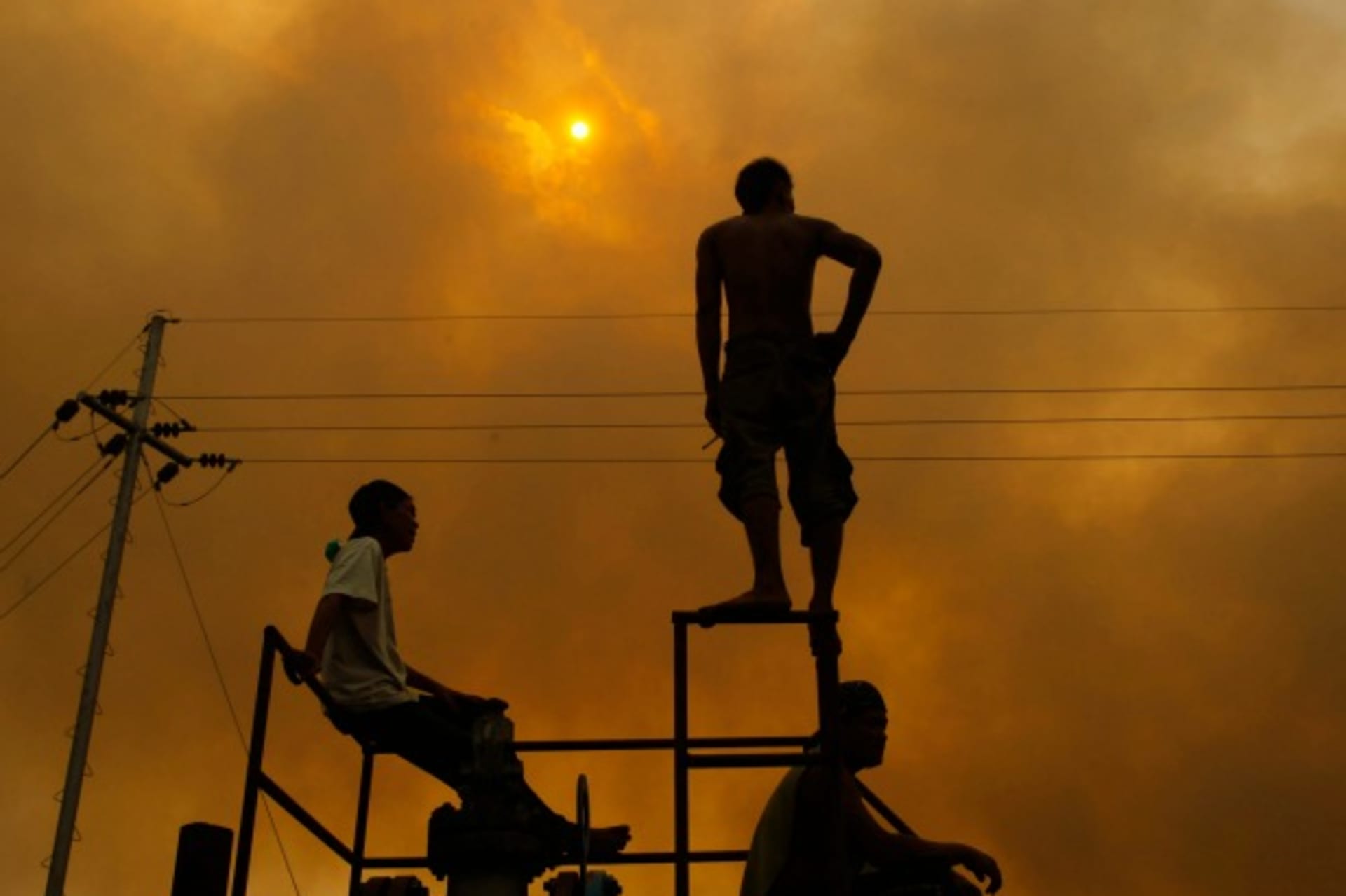 <p>A worker stands as he looks on at fire from burning trees planted for palm oil, during haze in Indonesia’s Riau province on June 24, 2013.</p>
