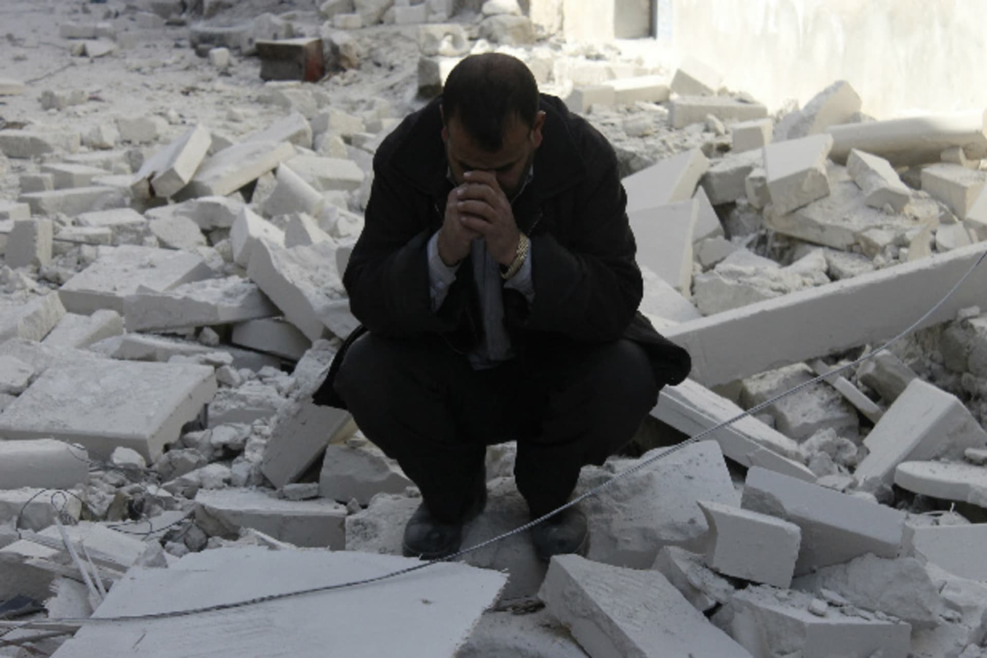 A man reacts at a site hit by what activists said was a barrel bomb dropped by forces loyal to Syria's president Bashar al-Assad in Masaken Hanano in Aleppo February 6, 2014 (Katan/Courtesy Reuters).