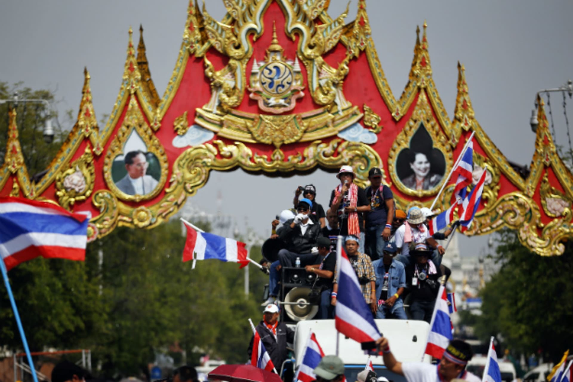 <p>Anti-government protesters celebrate under portraits of Thailand’s King Bhumibol Adulyadej and Queen Sirikit as they enter the area near the Government house in Bangkok on December 3, 2013. (Damir Sagolj/Courtesy Reuters)</p>
