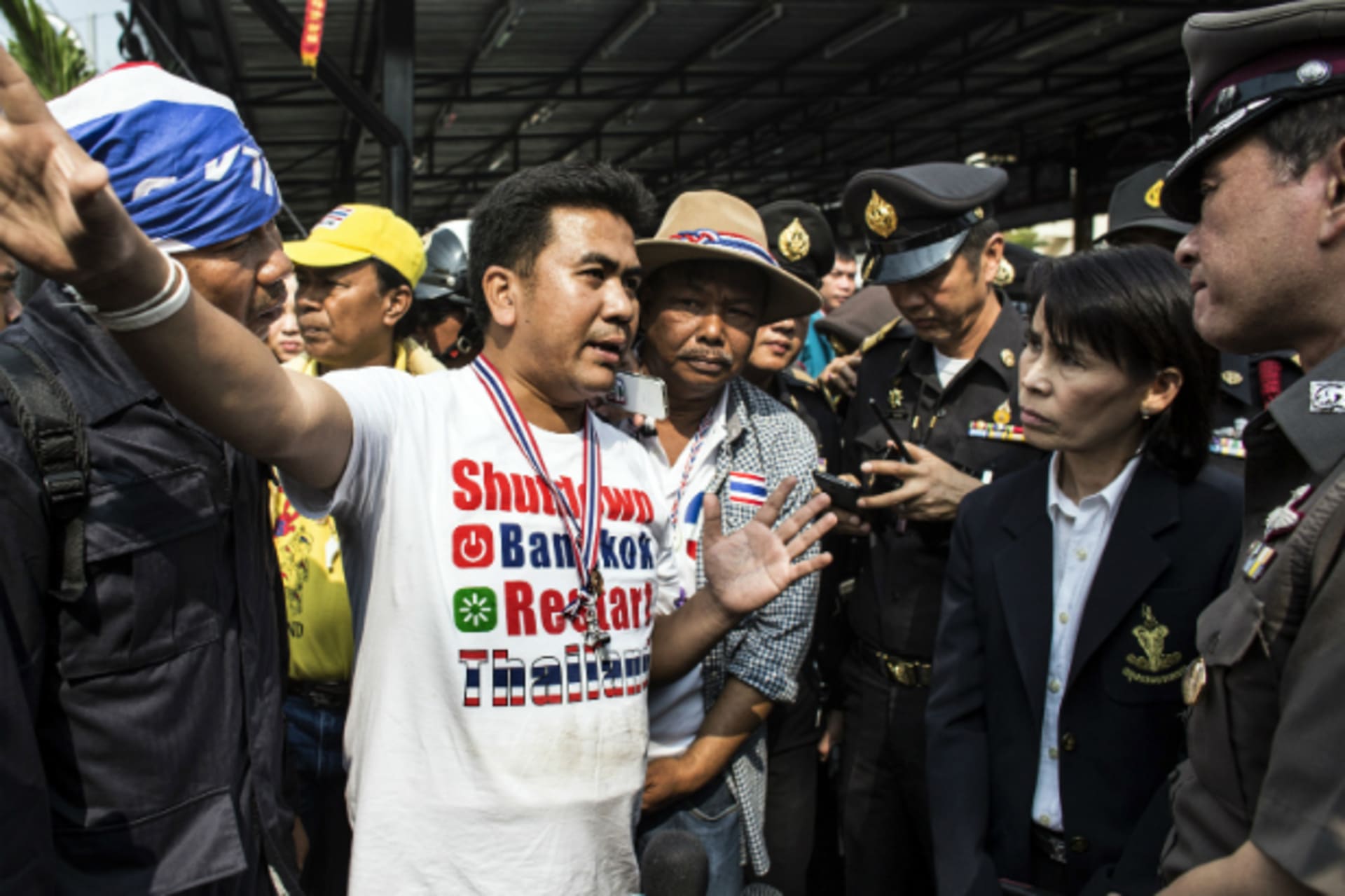 <p>An anti-government protester (C) negotiates with a local official and police officers regarding the closing of a polling stati…blocked its entrance during advance voting for a general election in Bangkok on January 26, 2014. (Nir Elias/Courtesy Reuters)</p>
