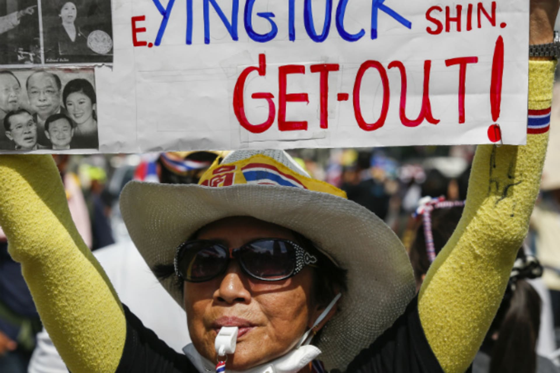 <p>An anti-government protester holds a placard as she gathers with others during a rally at a major business district in Bangkok on December 19, 2013. (Athit Perawongmetha/Courtesy Reuters)</p>
