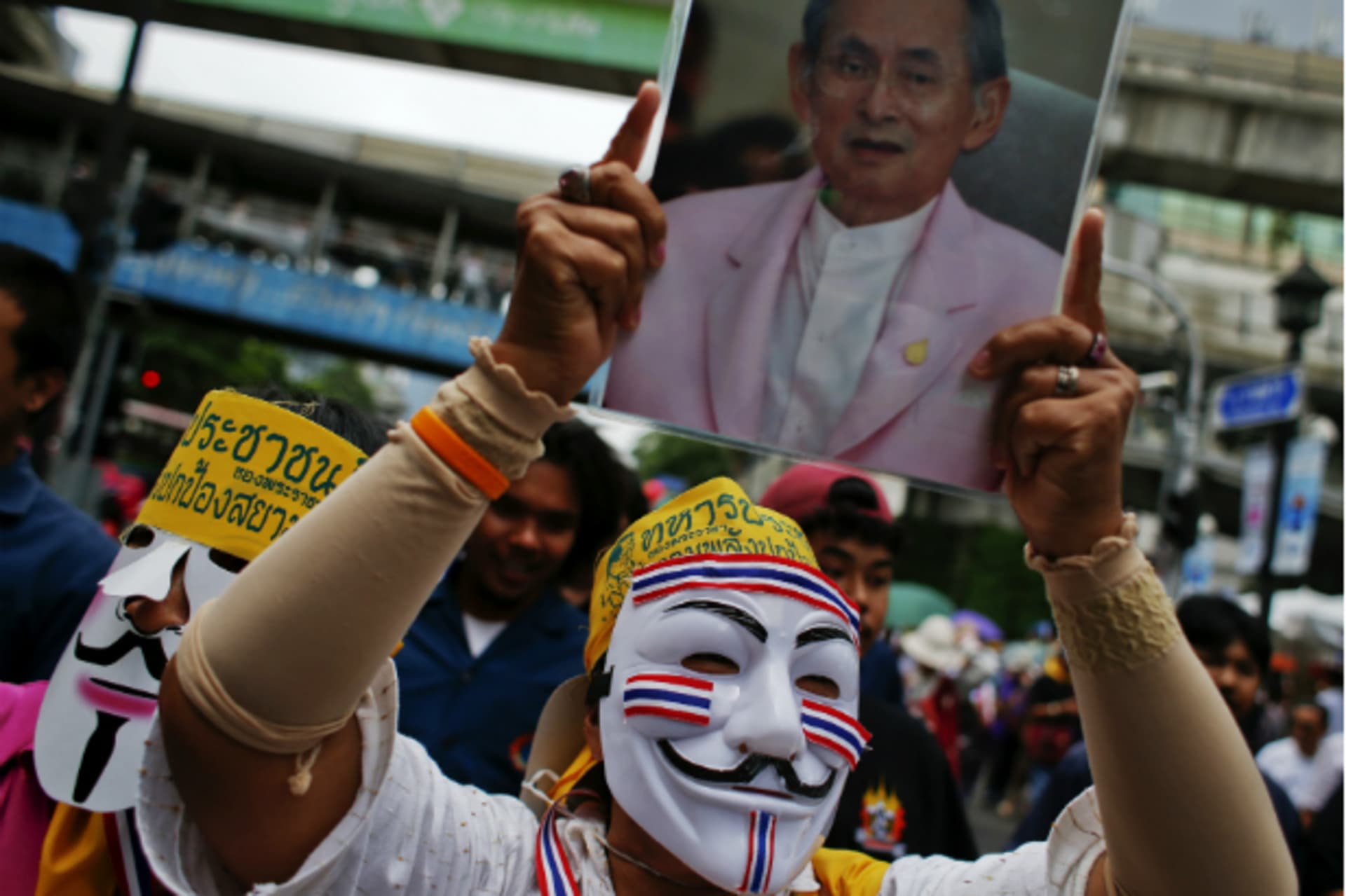 <p>An anti-government protester wearing a Guy Fawkes mask holds a picture of Thai King Bhumibol Adulyadej during a protest in Ban…x-premier Thaksin Shinawatra return from exile without having to serve a jail sentence. (Athit Perawongmetha/Courtesy Reuters)</p>
