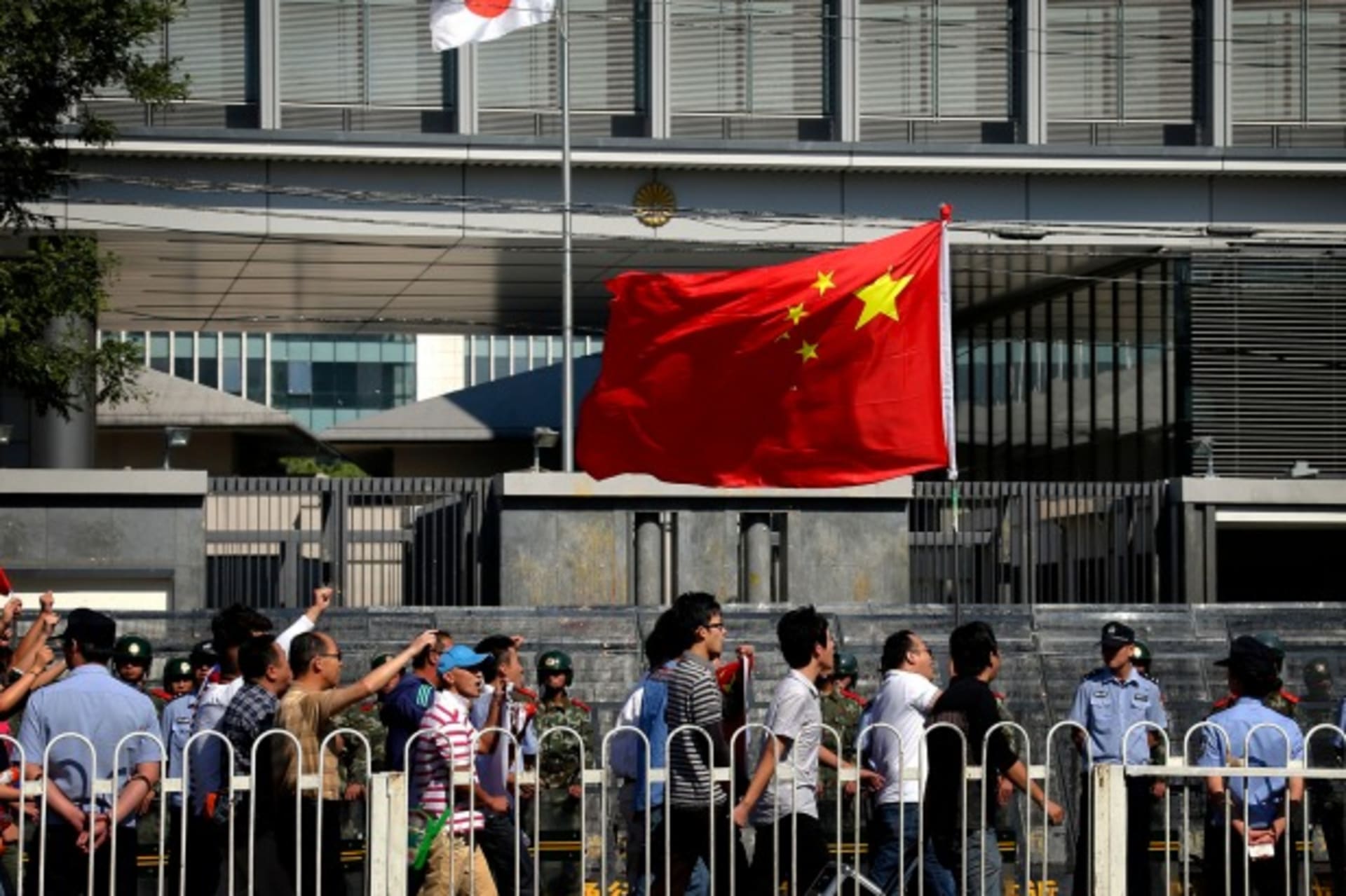 <p>Demonstrators chant slogans and carry a Chinese national flag as they march past riot police outside the main entrance to the …ry in a long-running row with Japan over a group of disputed islands. REUTERS/David Gray (CHINA – Tags: CIVIL UNREST POLITICS)</p>
