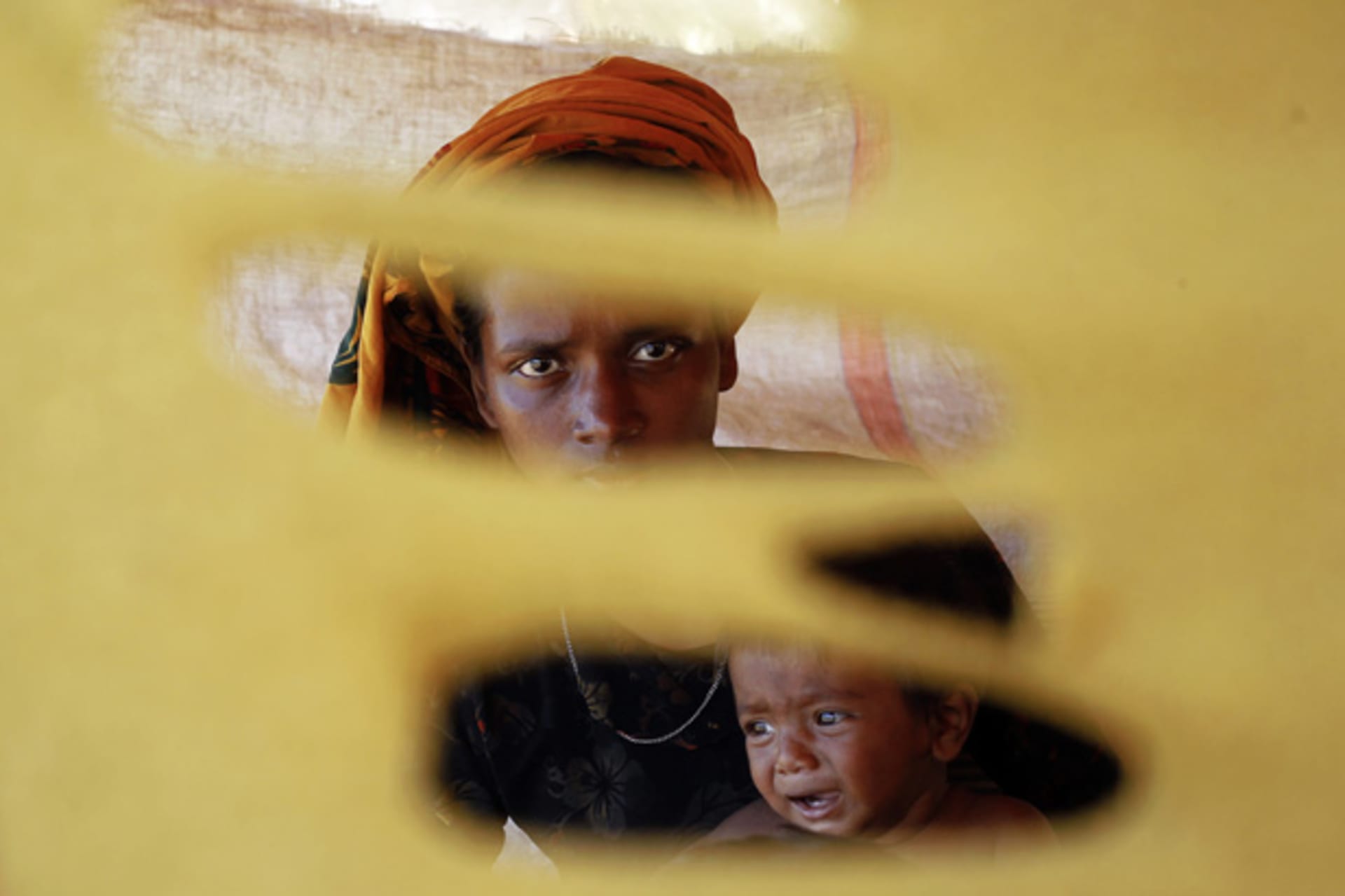 <p>A Rohingya woman, displaced by recent violence in Rakhine State, holds her crying child at a refugee camp for Muslims outside Sittwe, the capital of Rakhine.</p>
