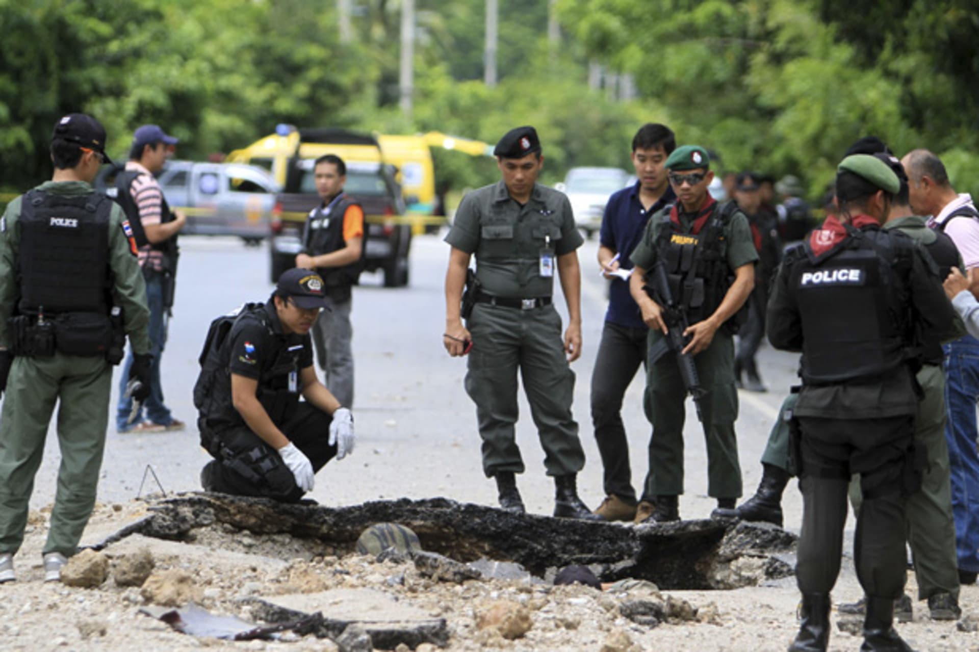 <p>Thai security personnel investigate the site of a bomb attack by suspected Muslim militants a roadside in southern Thailand’s Yala province October 6, 2012.</p>

