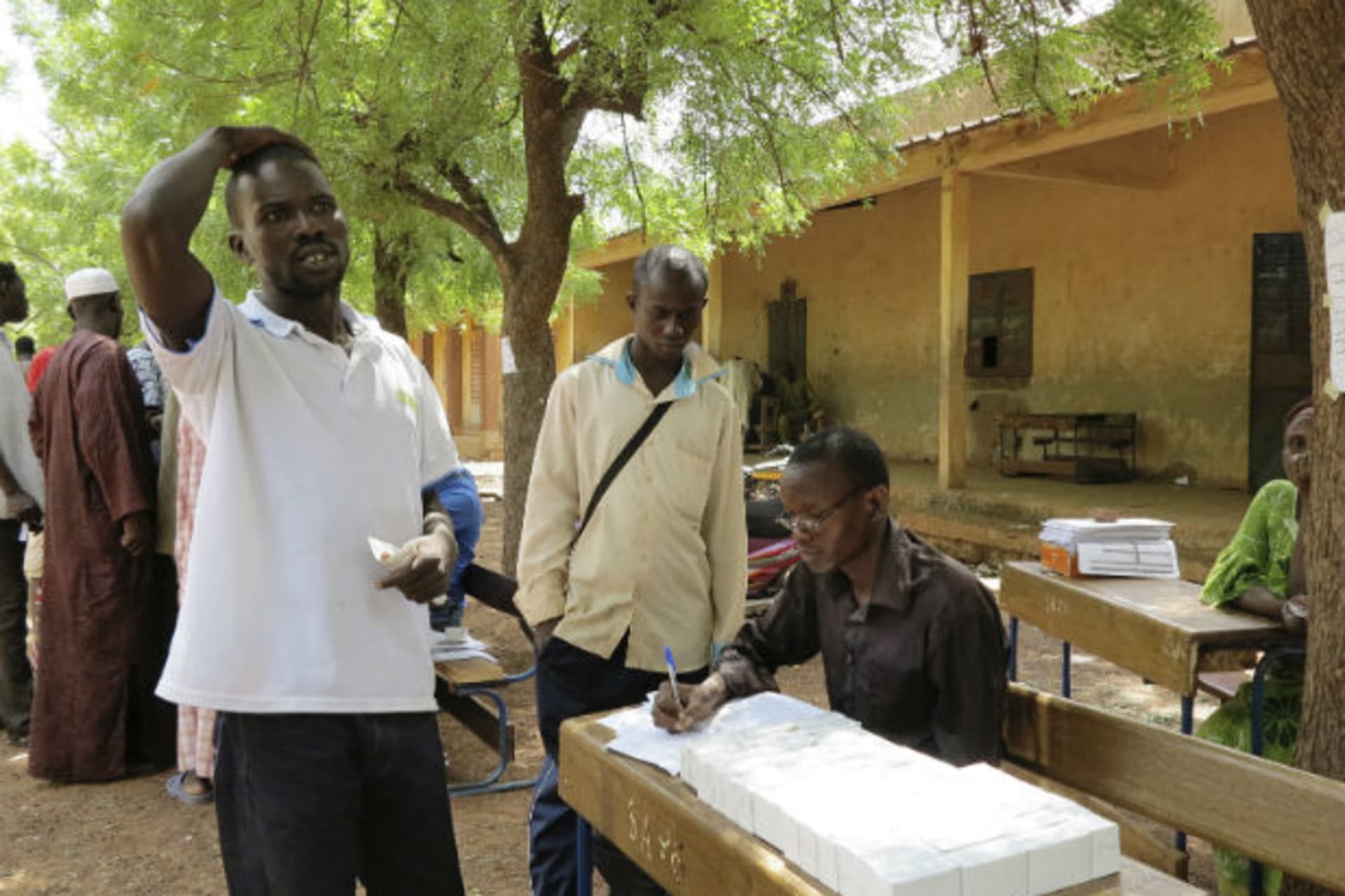 A man receives his voter identification card in Senou June 29, 2013.