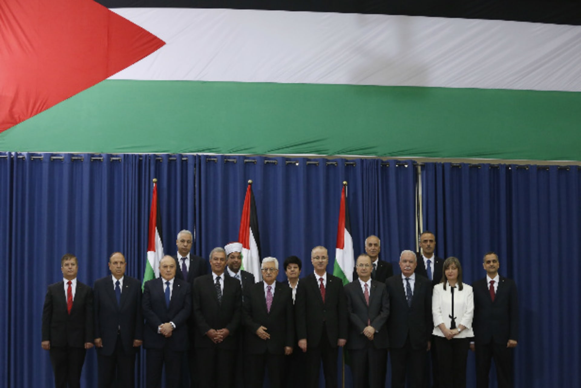 Palestinian prime minister Rami Hamdallah (6th L) and Palestinian president Mahmoud Abbas (5th L) pose for a group photo with Palestinian ministers during a swearing-in ceremony of the technocratic government, in the West Bank city of Ramallah