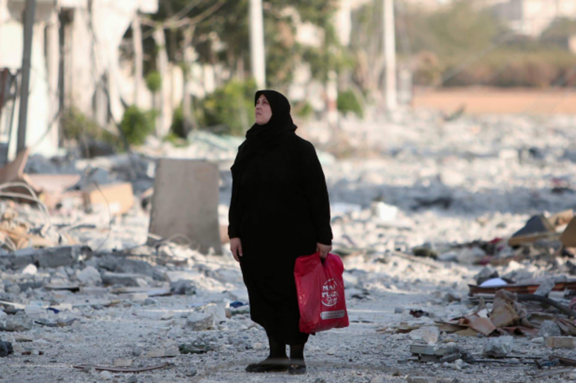 <p>A woman stands along a damaged street in Manbij, Aleppo Governorate, Syria (Rodi Said/Reuters).</p>
